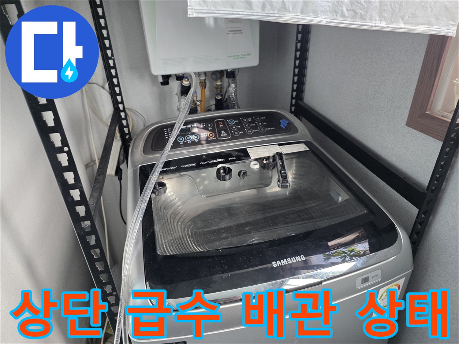 벽면에 설치된 온수탱크와 세탁기 연결 배관의 모습입니다.