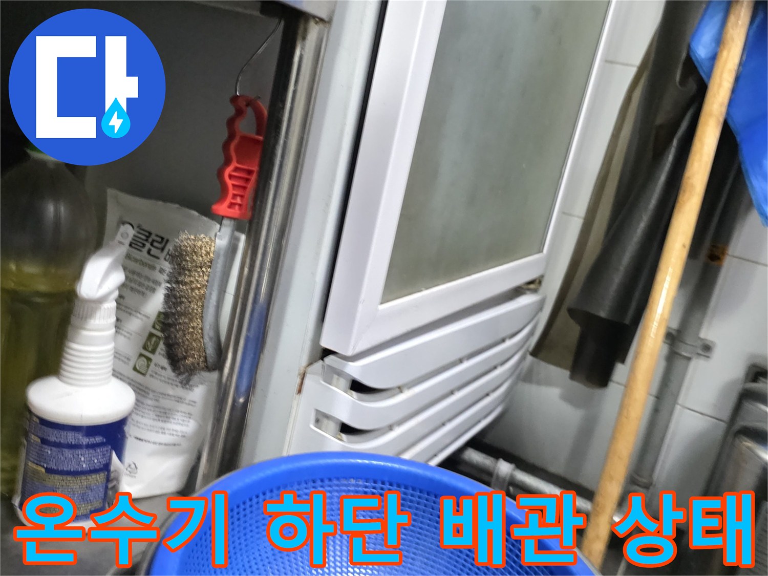 식당 온수기 아래쪽 배관 연결 부위와 주변 소품들