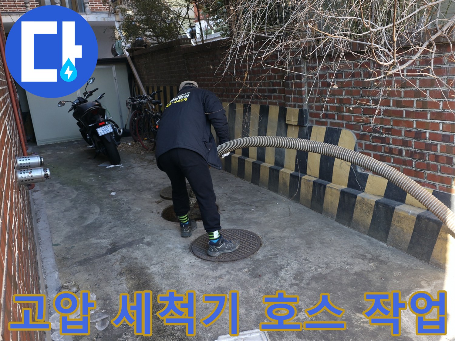 배수구 입구에 고압 세척 노즐을 삽입하여 배관 내부를 청소하는 과정