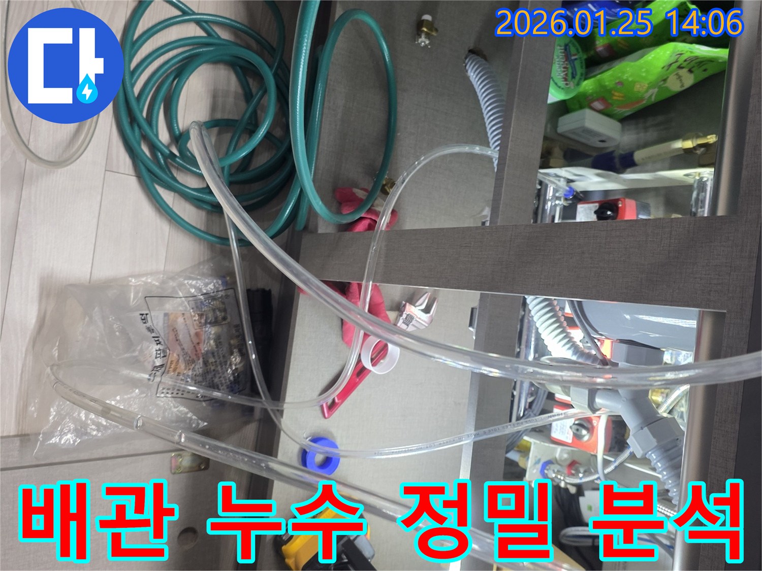 싱크대 하부 배관에서 발생한 누수를 정밀하게 분석하는 현장입니다-다양한 측정 장비와 호스를 사용하여-누수 지점을 정확히 찾아내고 있습니다.