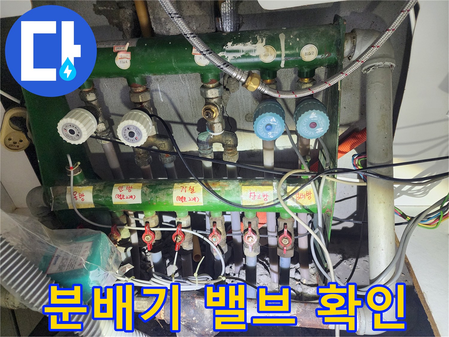 녹색 분배기에 연결된 다양한 크기의 수도 밸브 사진