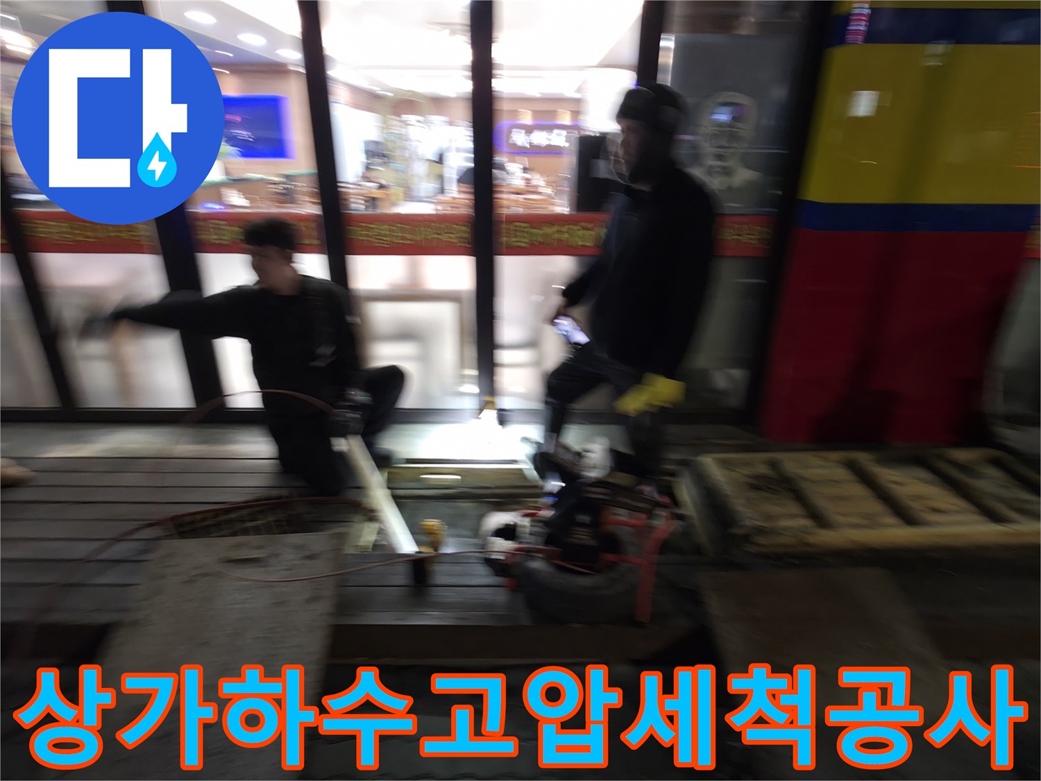 전문가가 고압 세척 장비를 운용하여 상가 메인배관의 막힘을 해결하는 모습