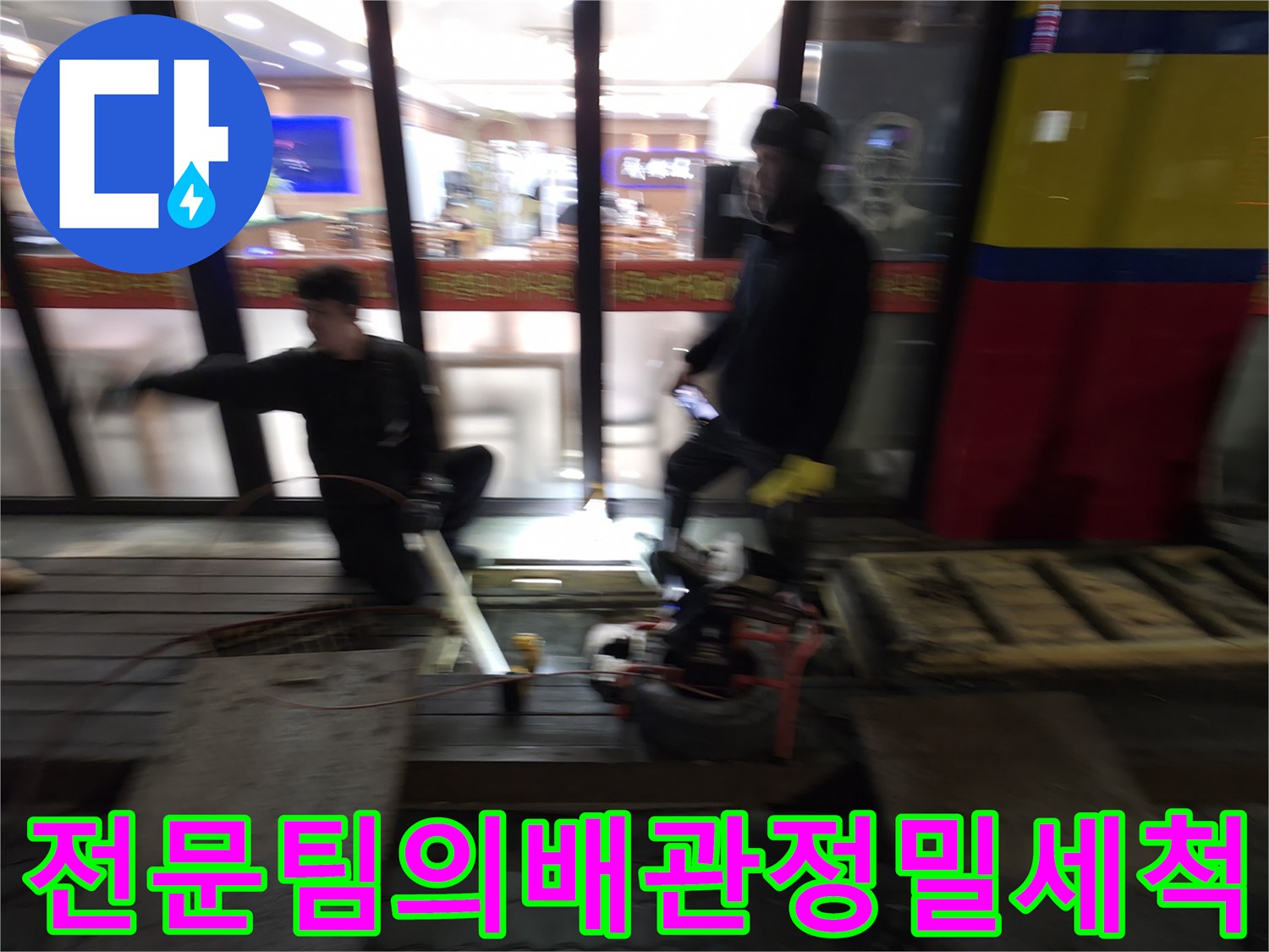 팀원들이 협력하여 장비를 운용하며 상가 하수 배관을 세척하는 장면