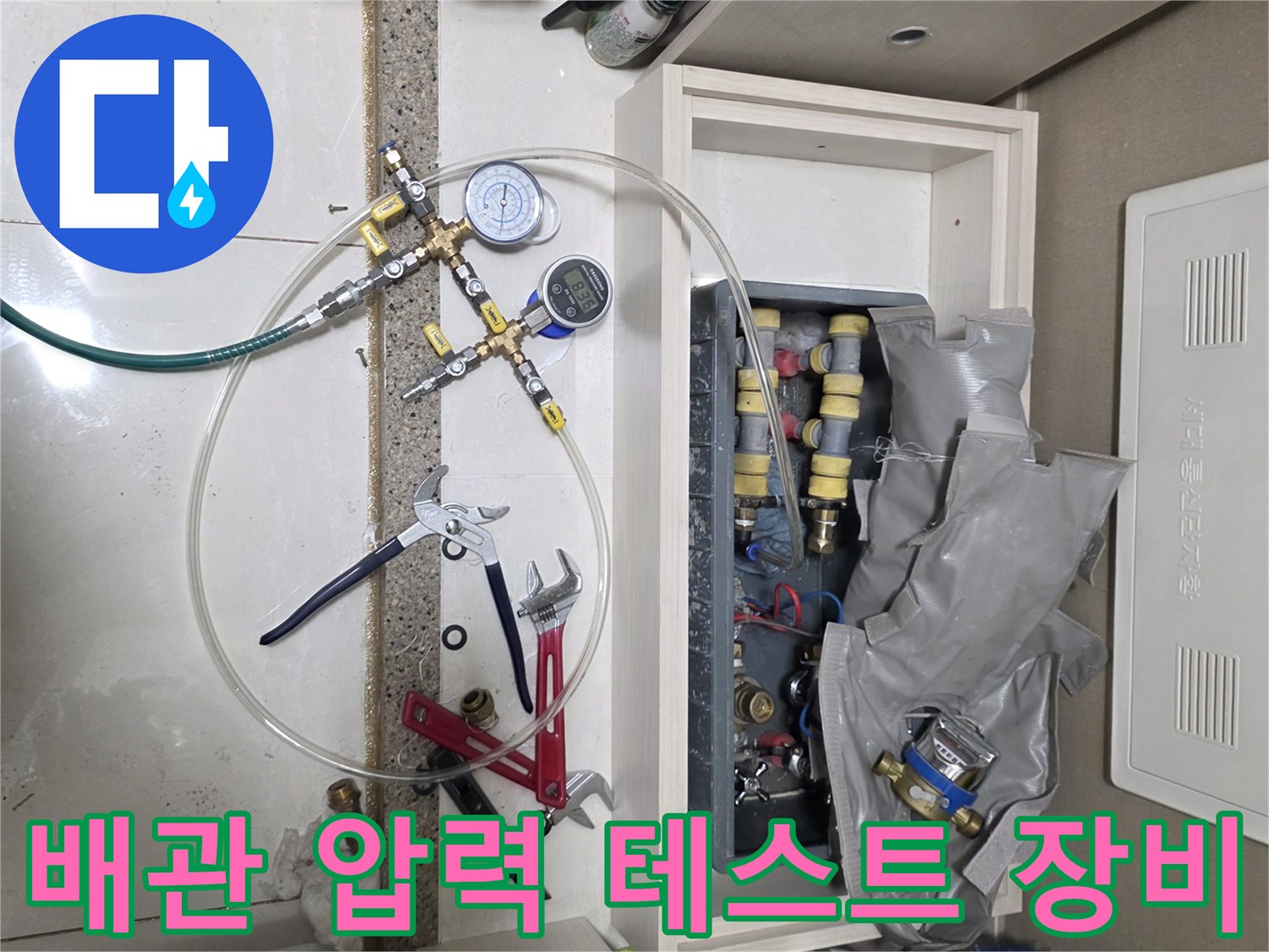 수도 배관의 기밀성을 확인하기 위해 설치된 공압 테스트용 게이지와 연결 호스들입니다.