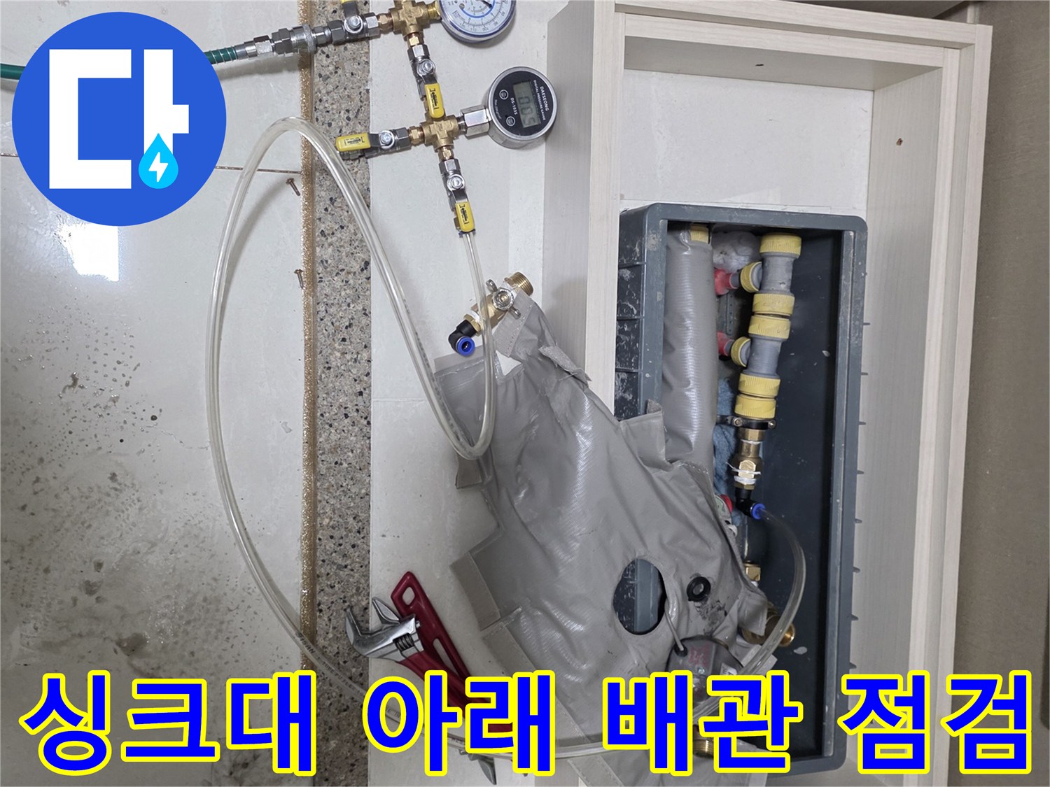 싱크대 하부장 내부-복잡한 배관 라인을-점검하는 압력계 장치