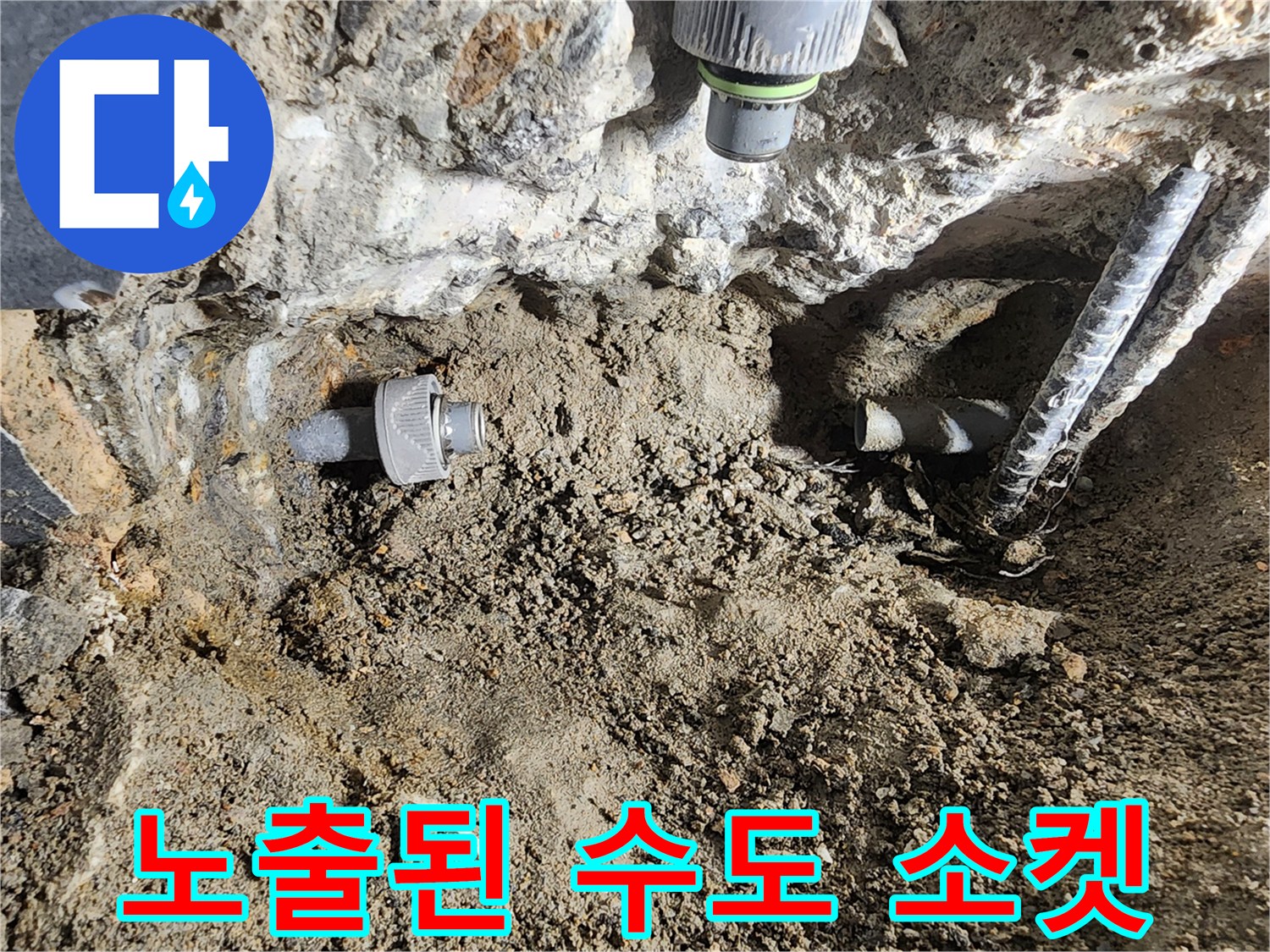 벽면 굴착 후 드러난 수도 연결 부속과 주변 토사