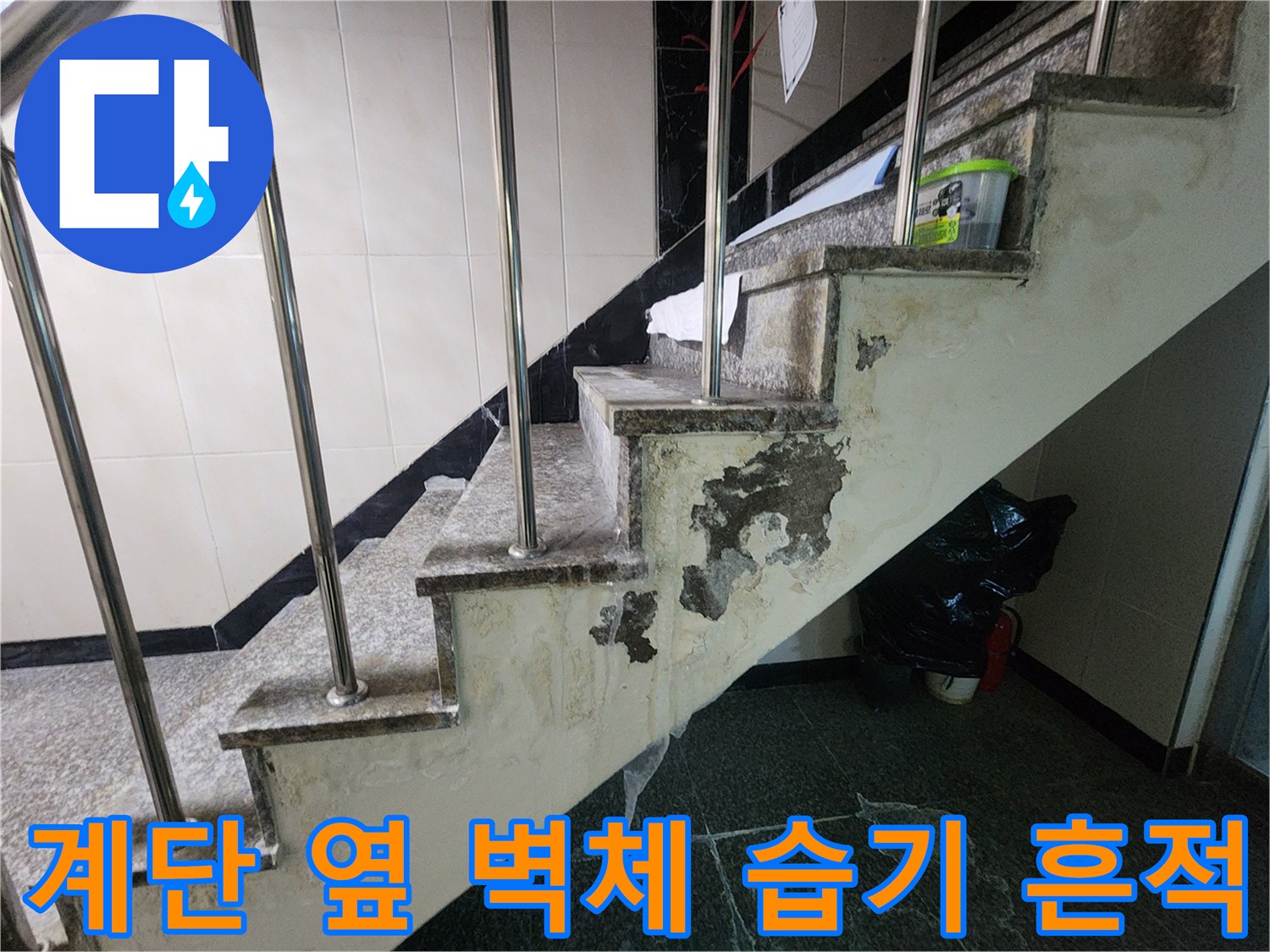 습기를 머금어 변색되고 벗겨진 계단 벽면 마감재 상태