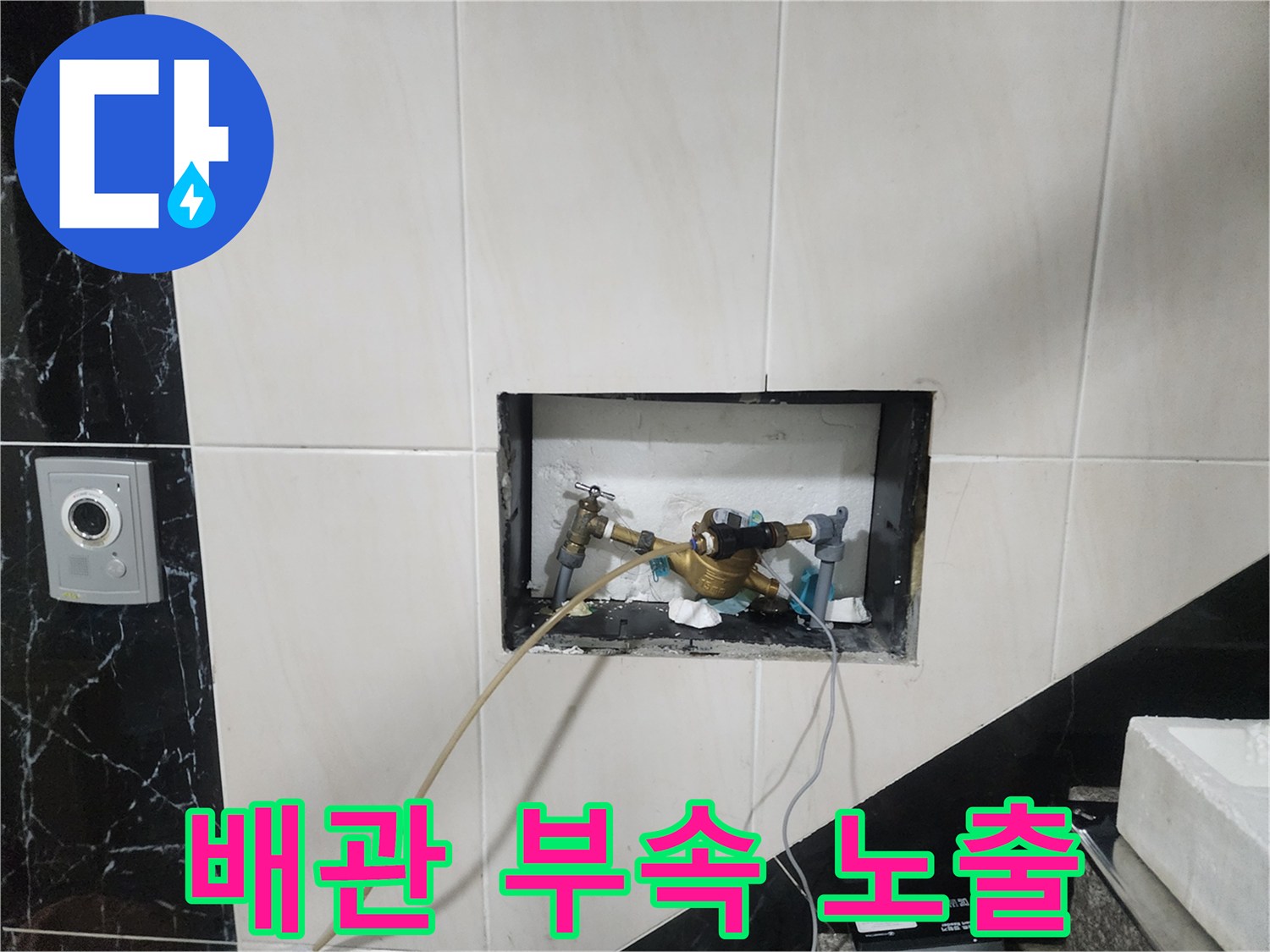 타일 뒤편에 위치한 급수 배관과 금속 연결 부위의 모습