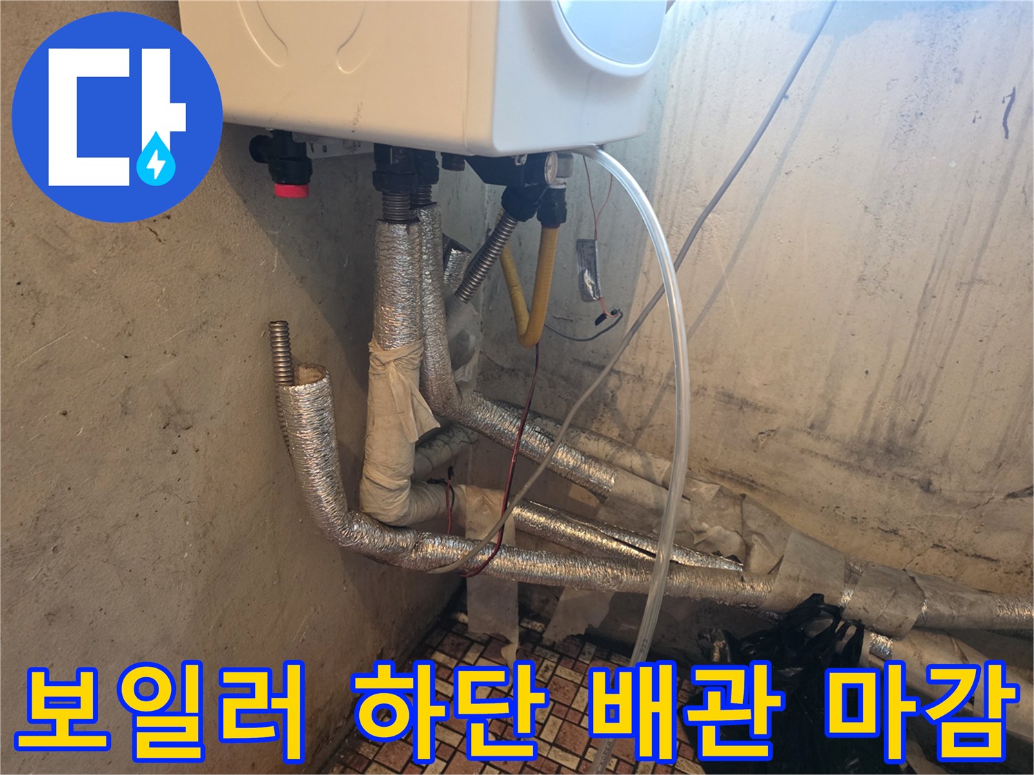 보일러 아래쪽-은색 단열재로 씌워진 보일러 배관 연결부