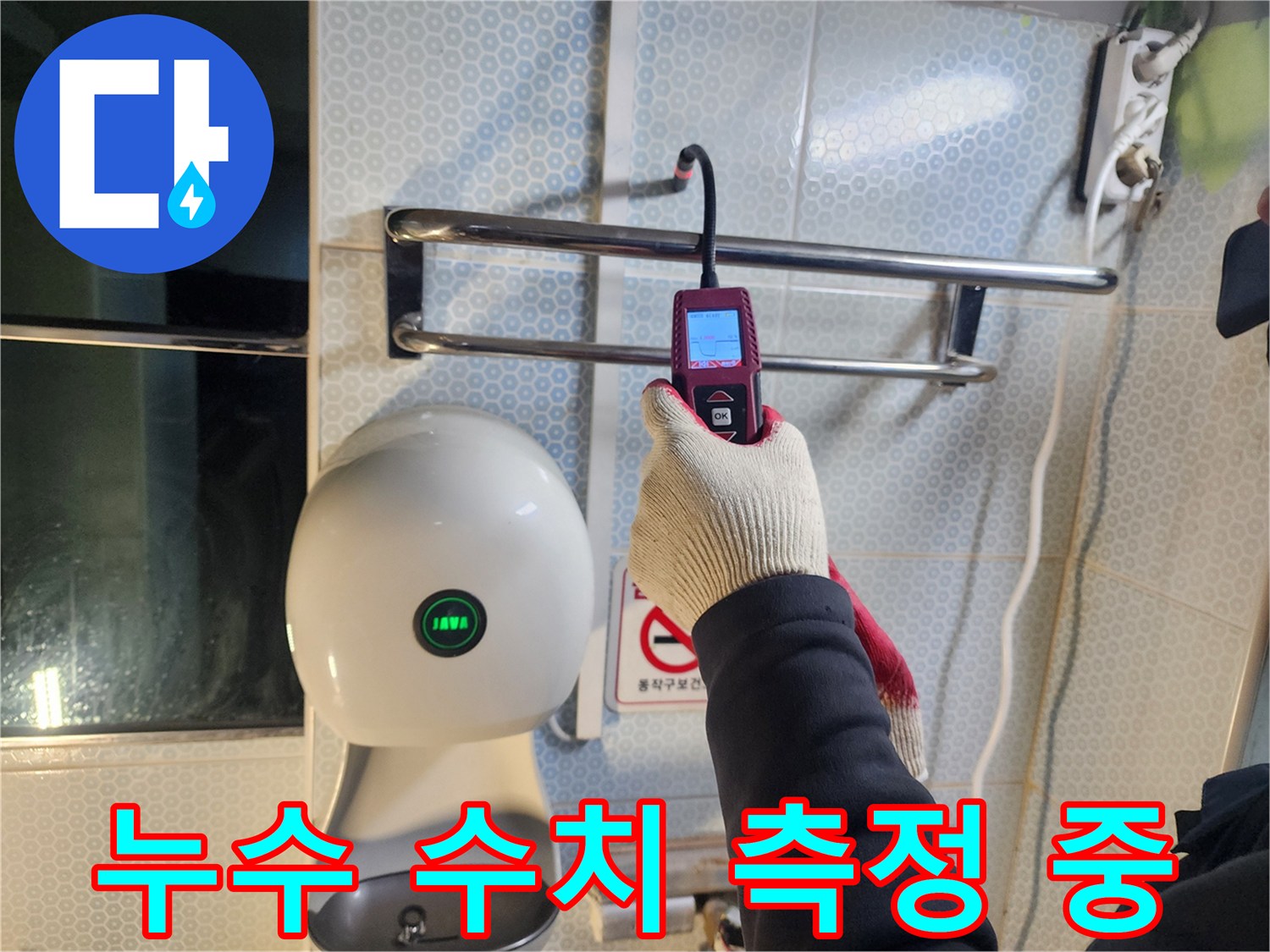 소변기 주변 벽면에 탐지 장비를 대고 누수 여부를 확인하는 작업 장면