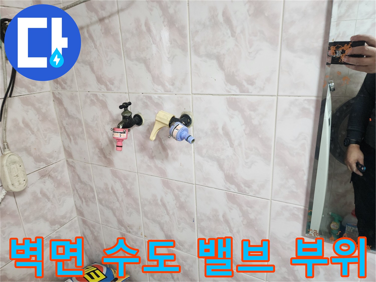 타일 벽면에 노출된 배관 연결 부속과 밸브의 상세 모습입니다.