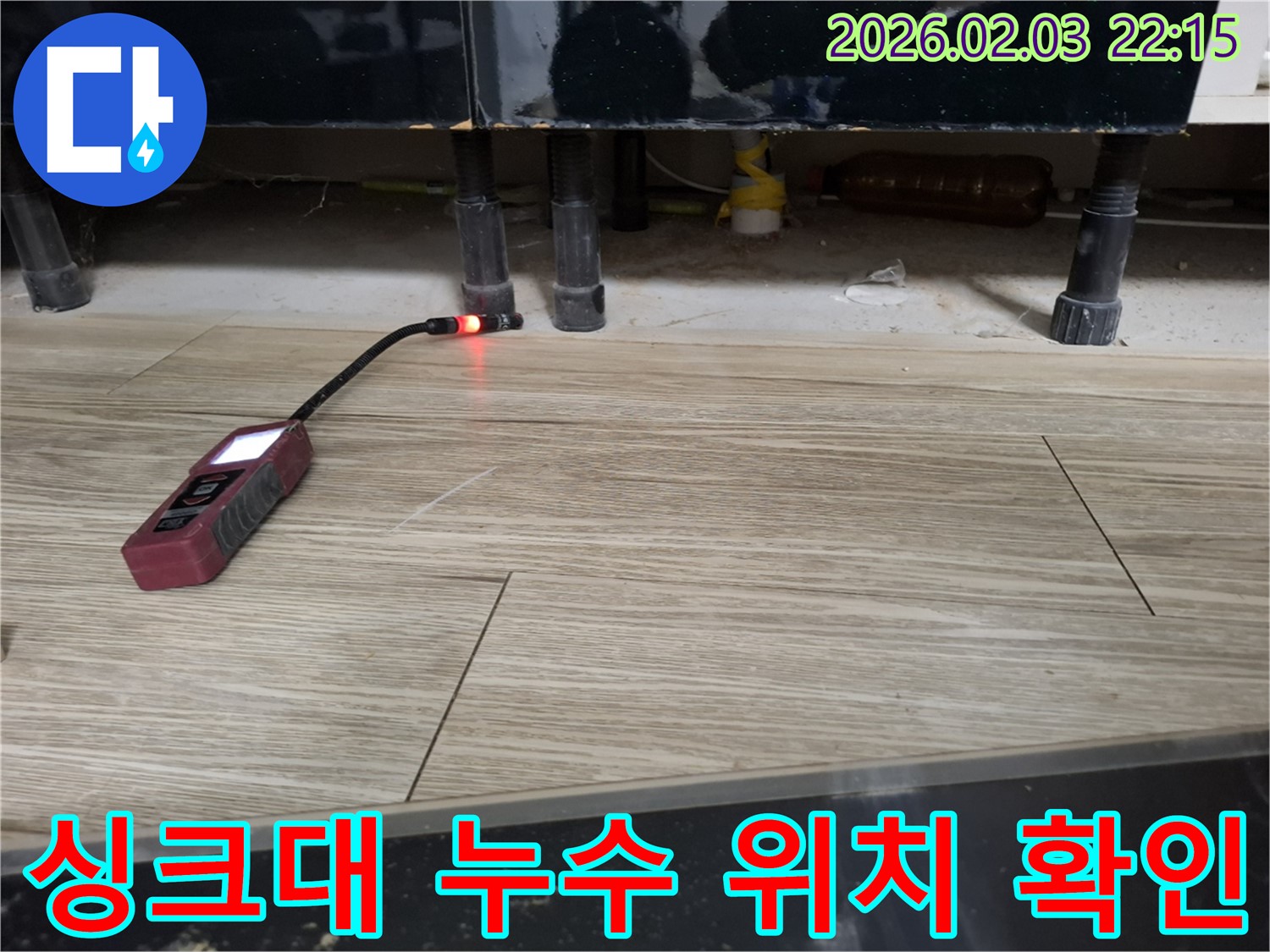 싱크대 아래에서 누수 탐지 장비로 누수 위치를 확인하는 모습 - 어두운 곳도 문제없이 찾아냅니다.