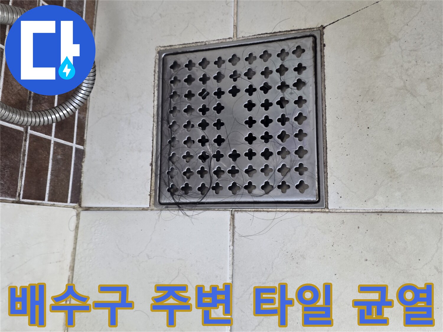 욕실 배수구 덮개와 갈라진 타일의 모습