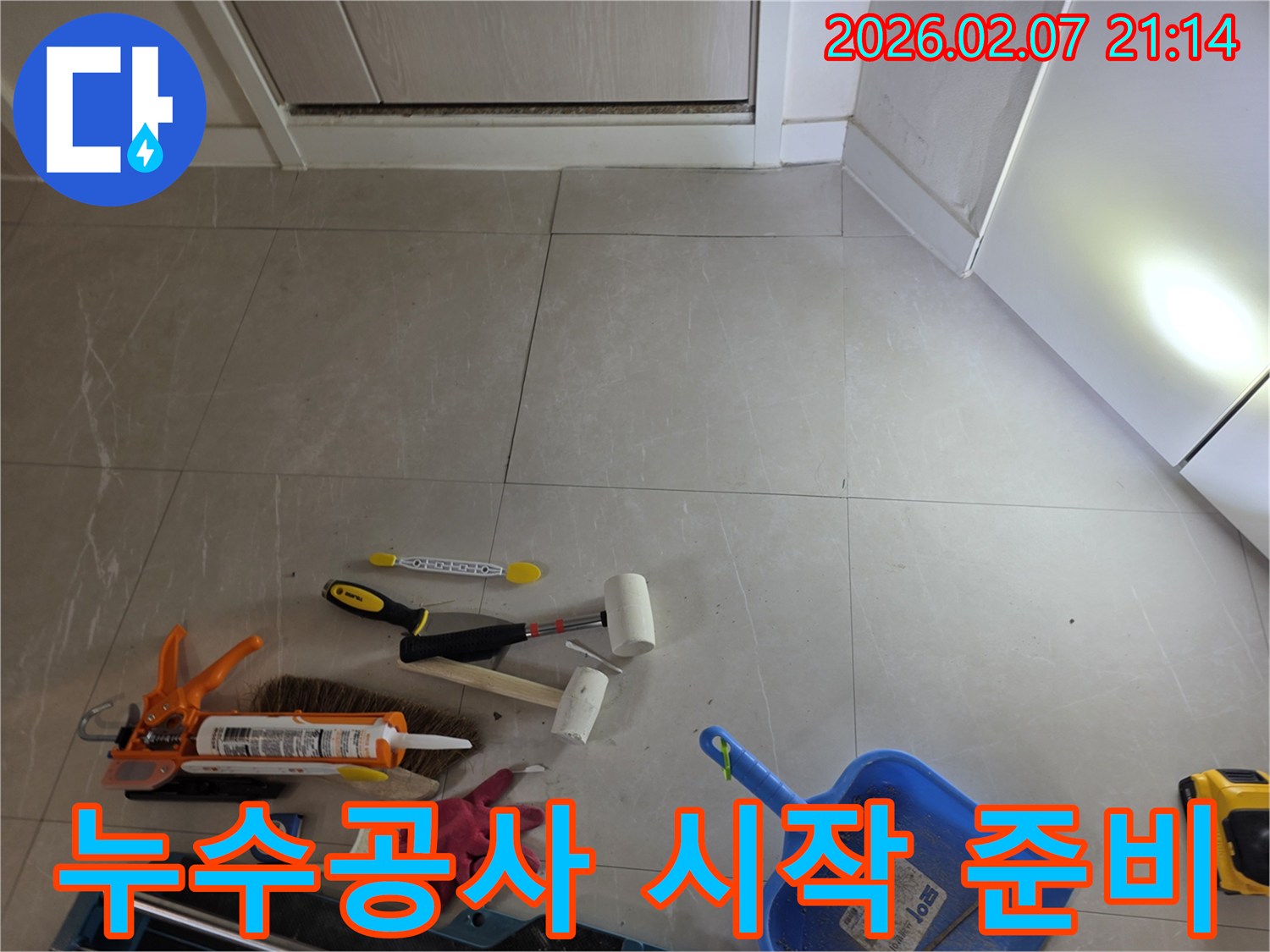 누수-보수-작업을-위해-필요한-다양한-수공구와-청소-용품들이-타일-바닥에-준비되어-있는-현장-사진입니다