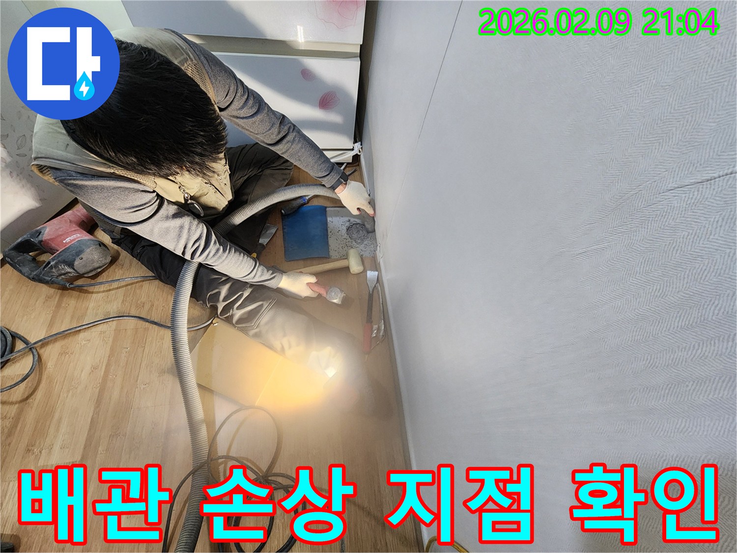 누수 전문 엔지니어가 배관 손상 지점을 정확히 확인하기 위해 벽면 마감재를 조심스럽게 제거하고 있습니다.