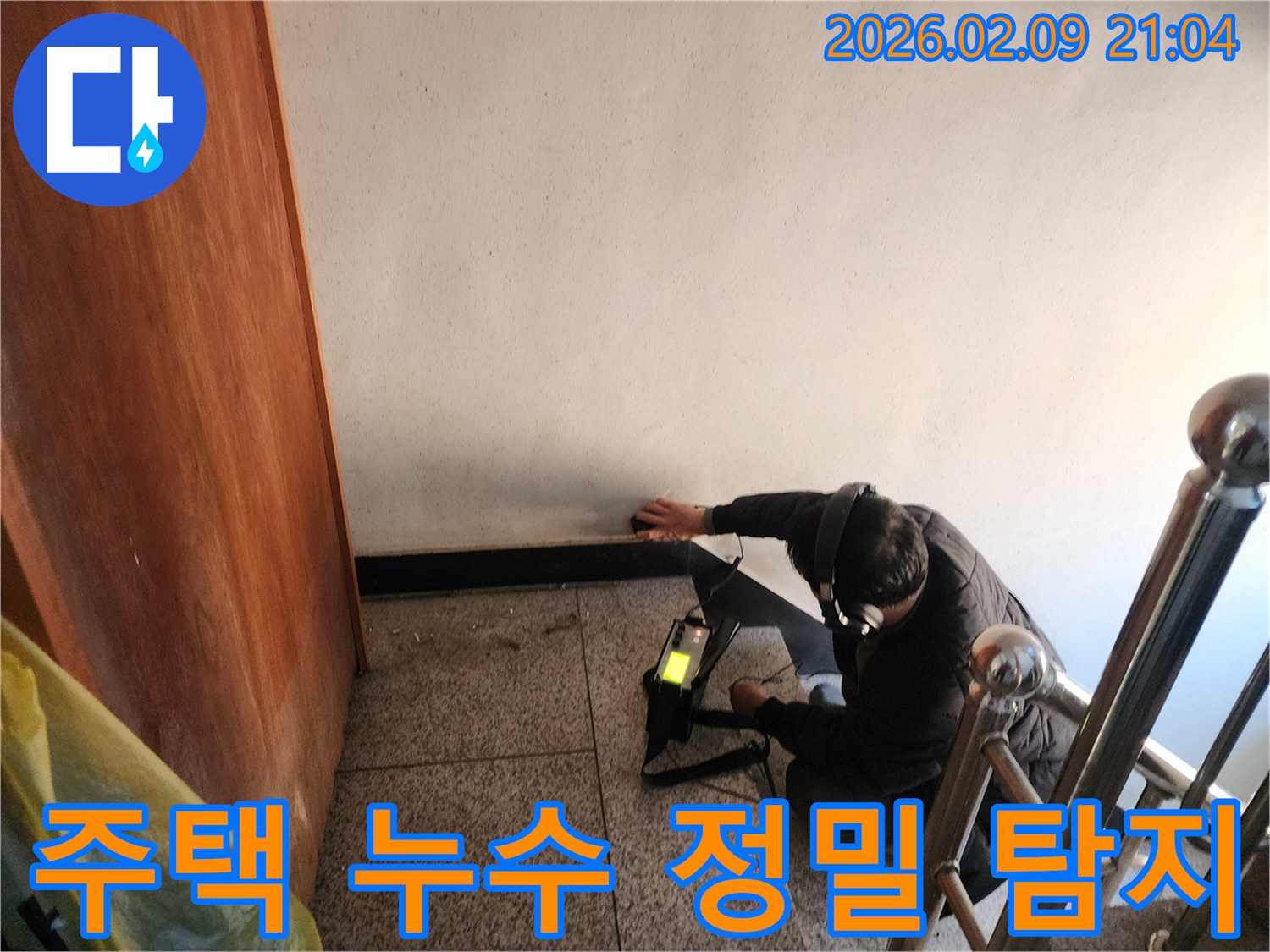 전문-기술자가-주택-벽면에서-누수-탐지-장비를-사용하여-미세한-물샘-소리를-꼼꼼하게-듣고-있는-모습