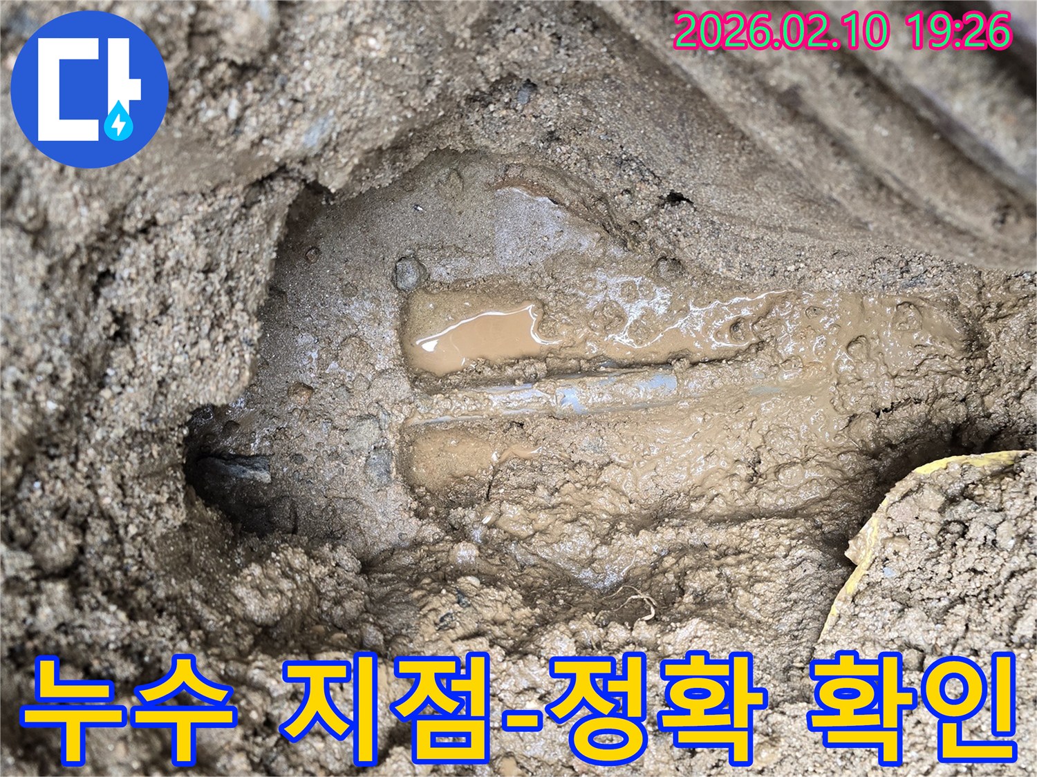 흙 속에 묻힌 배관에서-물이 새어 나와 고여있는-누수 발생 현장의 모습