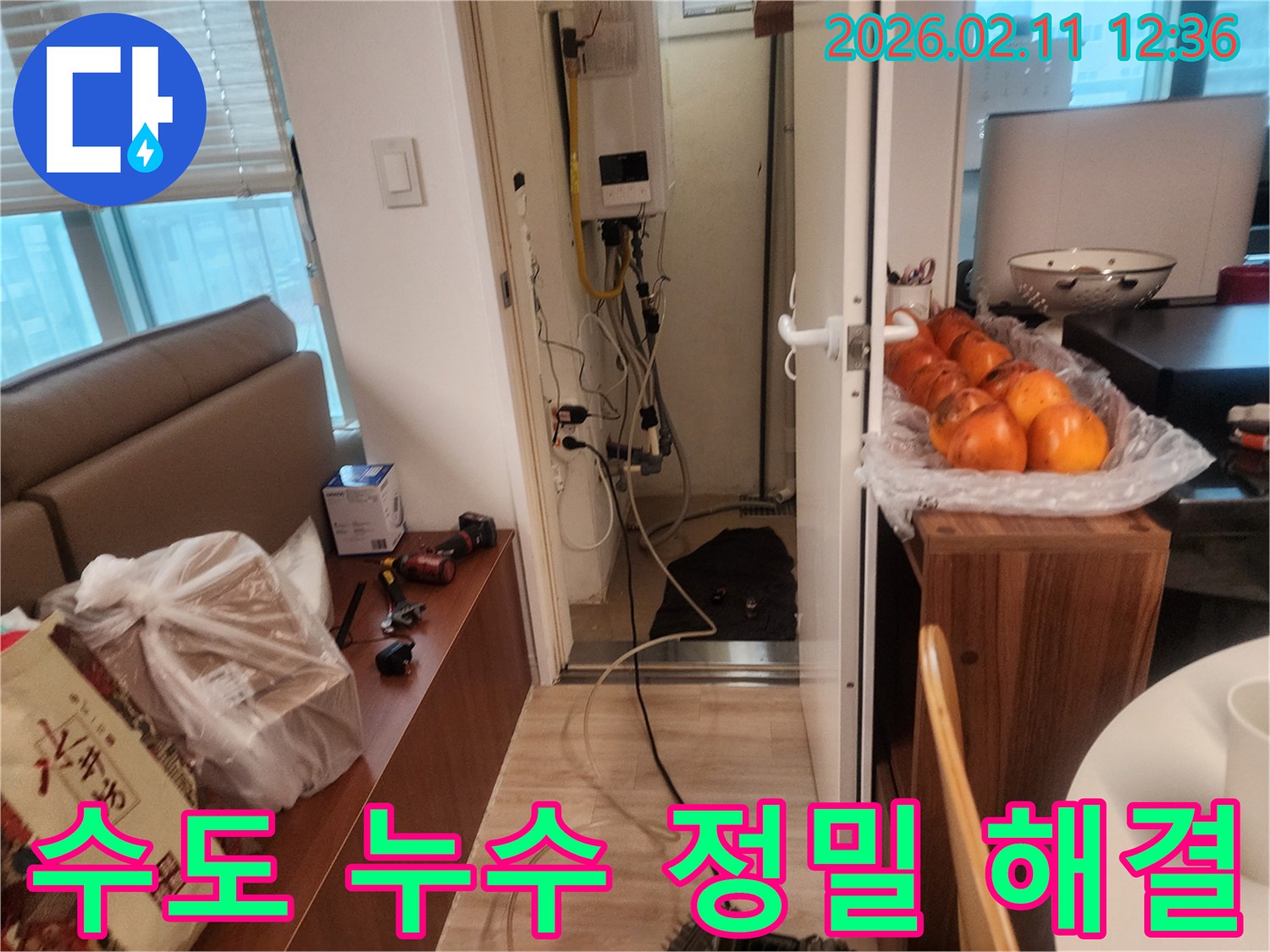이 이미지는 동대문구 회기로 아파트에서 발생한 수도 누수를 정밀하게 탐지하고 해결하기 위해 전문가가 보일러실을 점검하는 모습입니다.