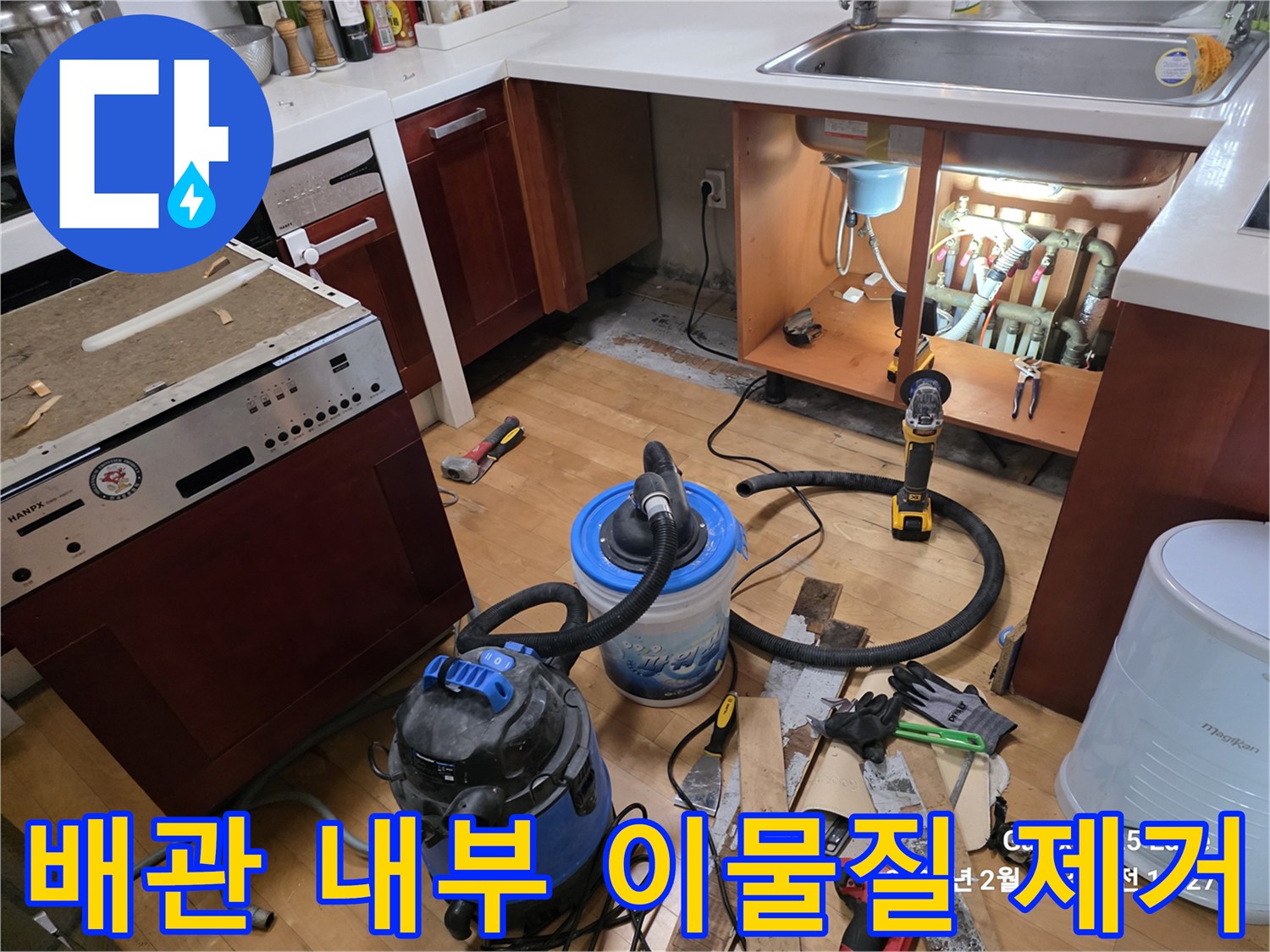 싱크대 밑 작업 현장-석션기와 전동 드릴 등 공구 배치