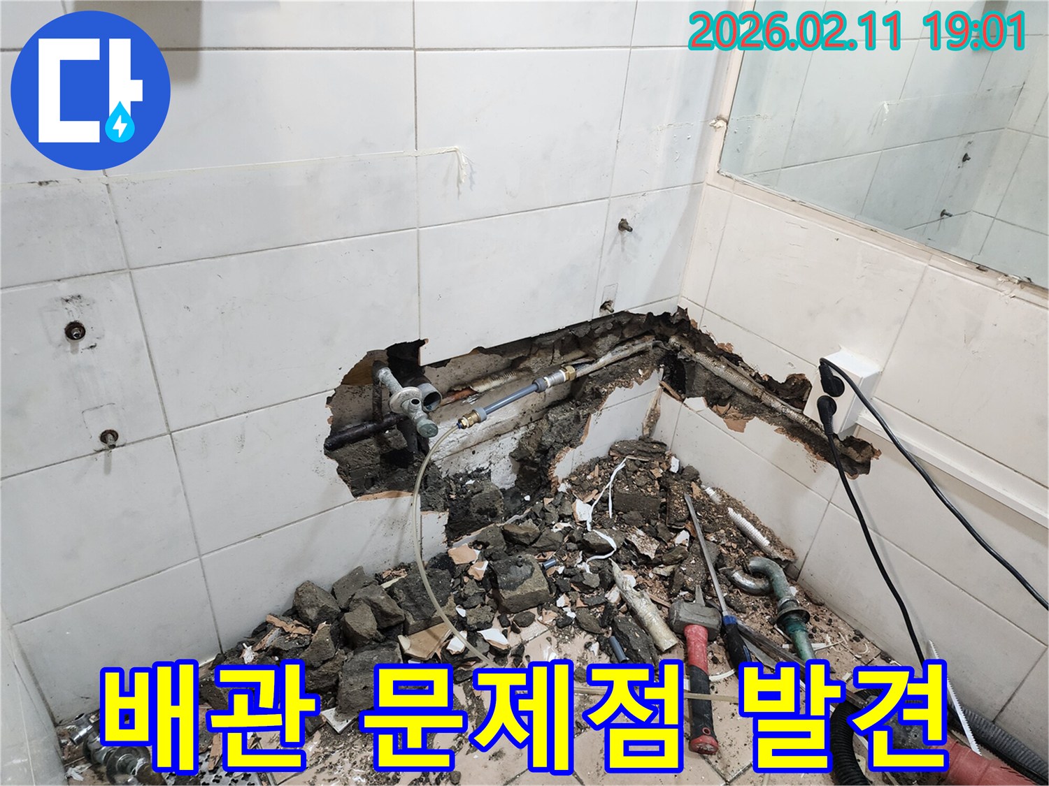 용산구에서 진행된-누수공사 현장에서-벽면 파쇄를 통해-배관의 문제점을-발견하는-전문가의-작업 모습입니다.