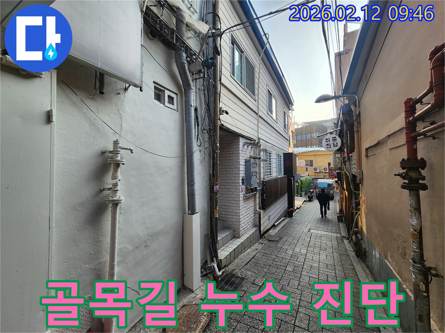 서울-중구-좁은-골목길에-위치한-건물에서-누수-진단을-위해-외벽과-주변-환경을-살펴보는-모습입니다