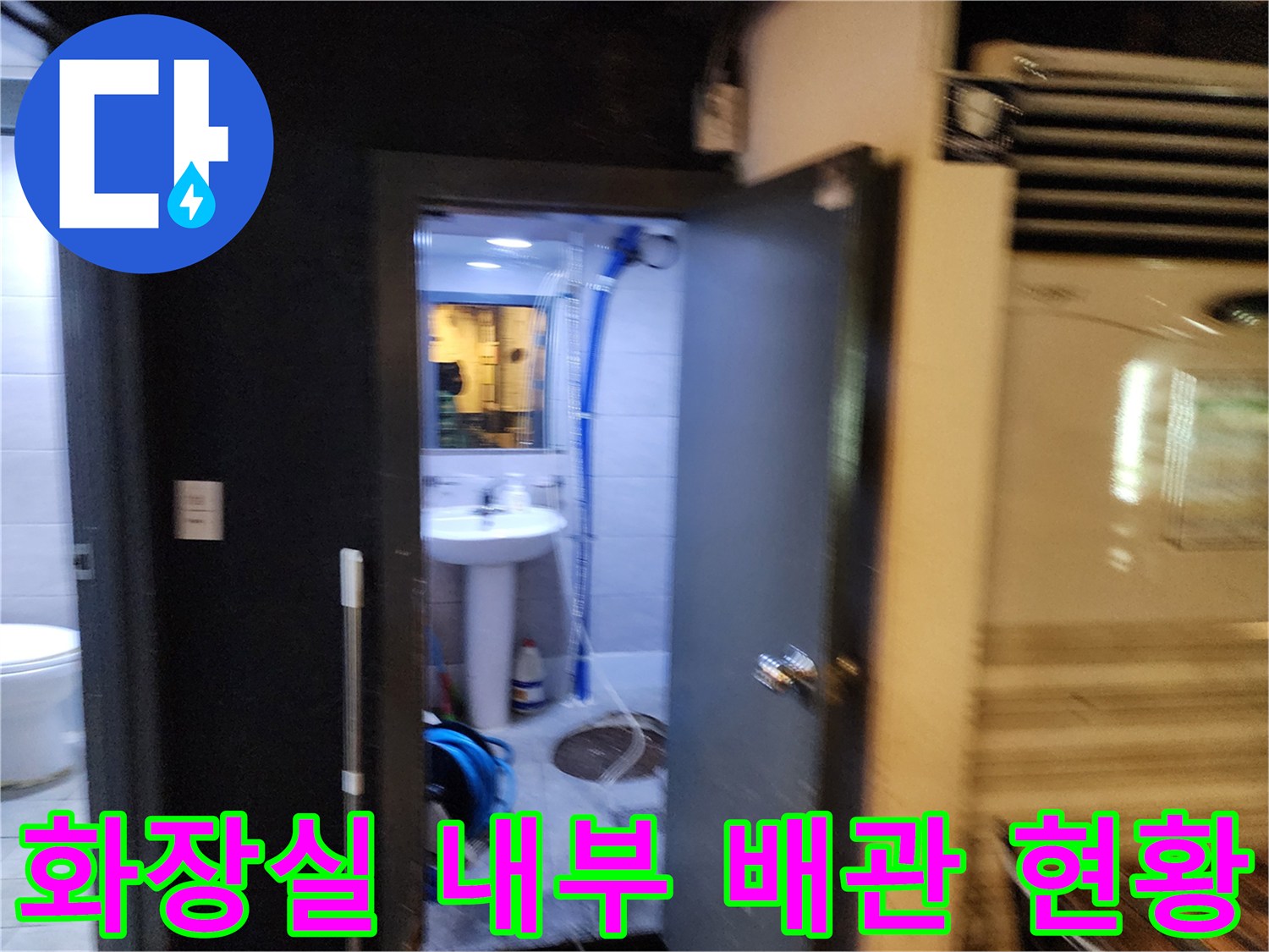세면대 밑으로 이어지는 파란색 호스와 바닥의 배수 구조물
