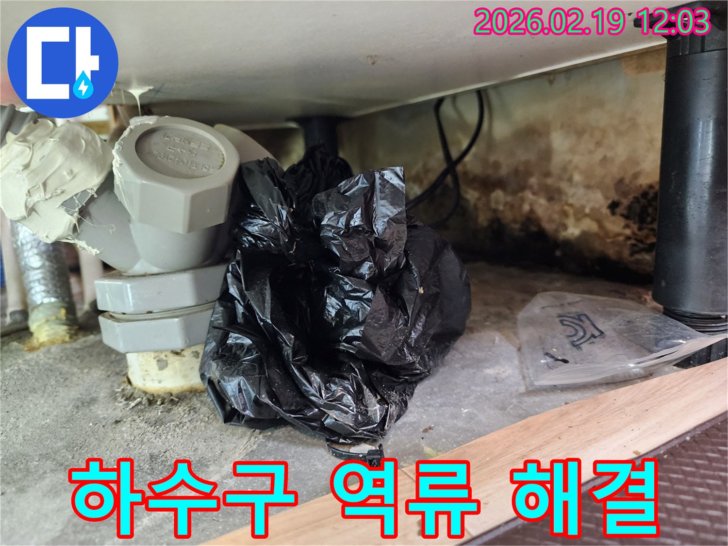 이 이미지는 하수구 역류로 인해 싱크대 하부가 오염되고-곰팡이가 발생한 현장을 보여줍니다.