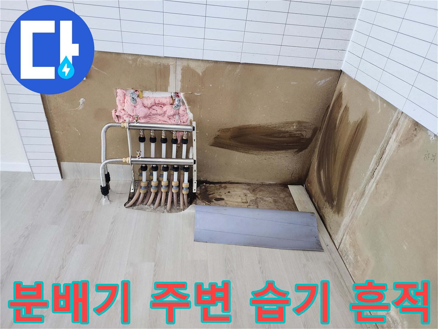 물샘으로 인해 젖고 변색된 벽면과 분배기 배관의 모습입니다.