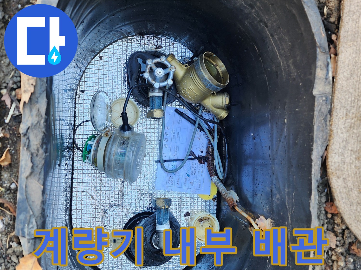 수도 계량기함 내부에 설치된 황동색 계량기와 연결 부위