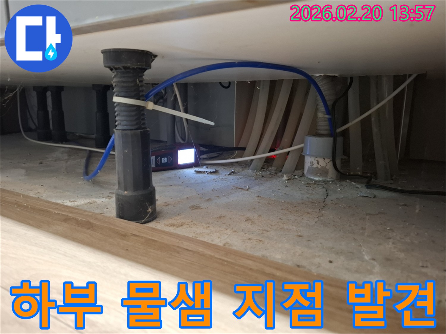 어둡고 좁은 싱크대 하부에서-누수탐지 장비의 불빛으로-숨겨진 물샘 지점을-정확히 찾아내는 모습입니다