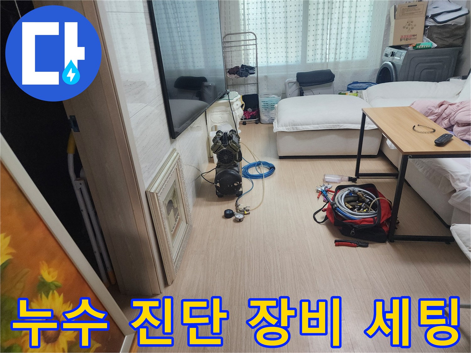 거실 바닥에 배치된 누수 탐지용 전문 장비와 호스