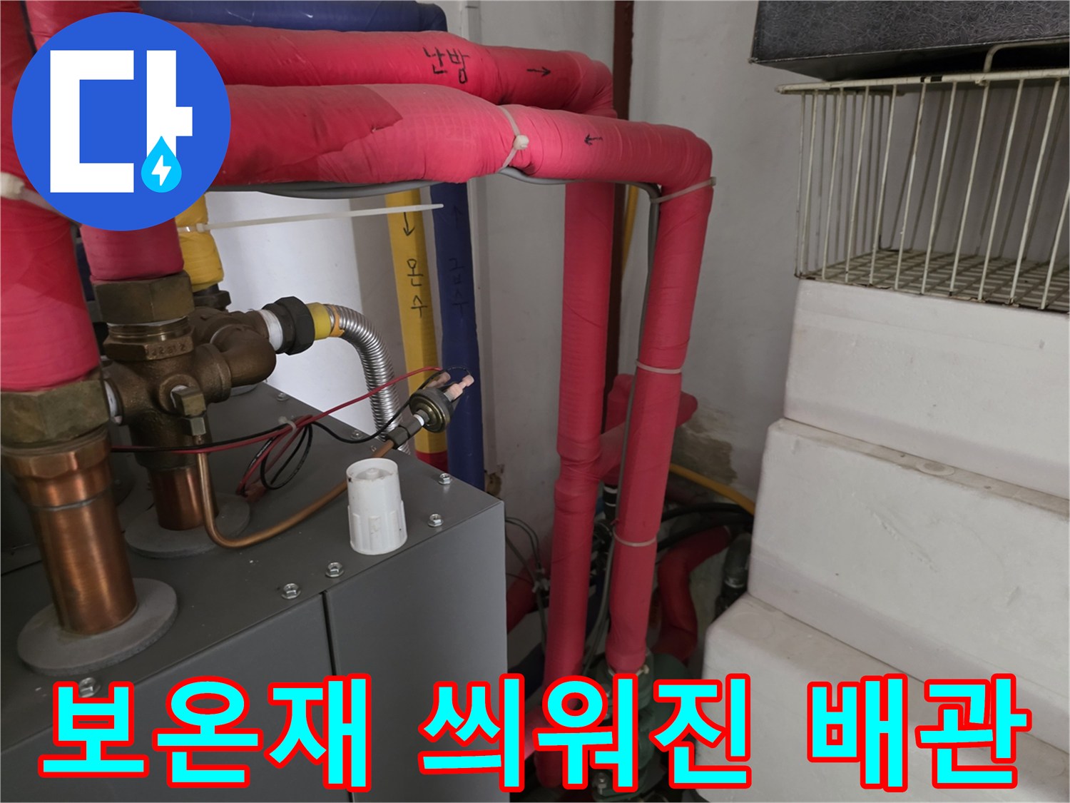 분홍색 보온재가 감긴 난방용 배관과 금속 부품 상세