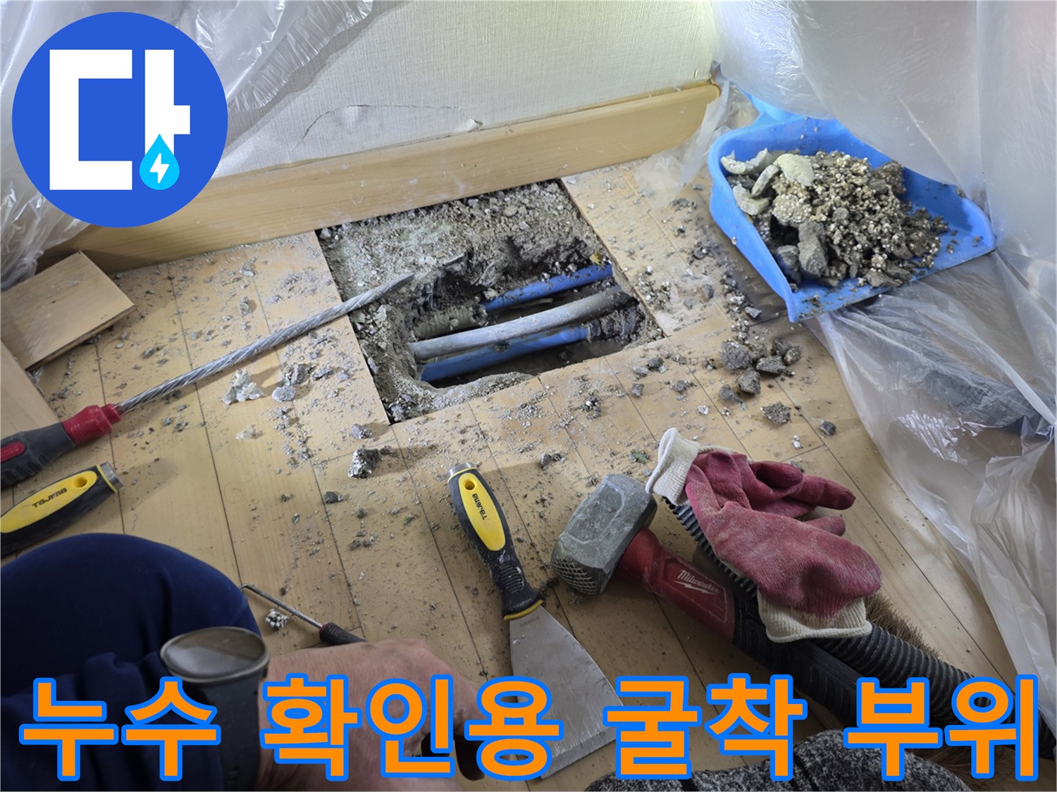 바닥을 파헤쳐 드러난 파란색 난기 배관과 작업 도구들