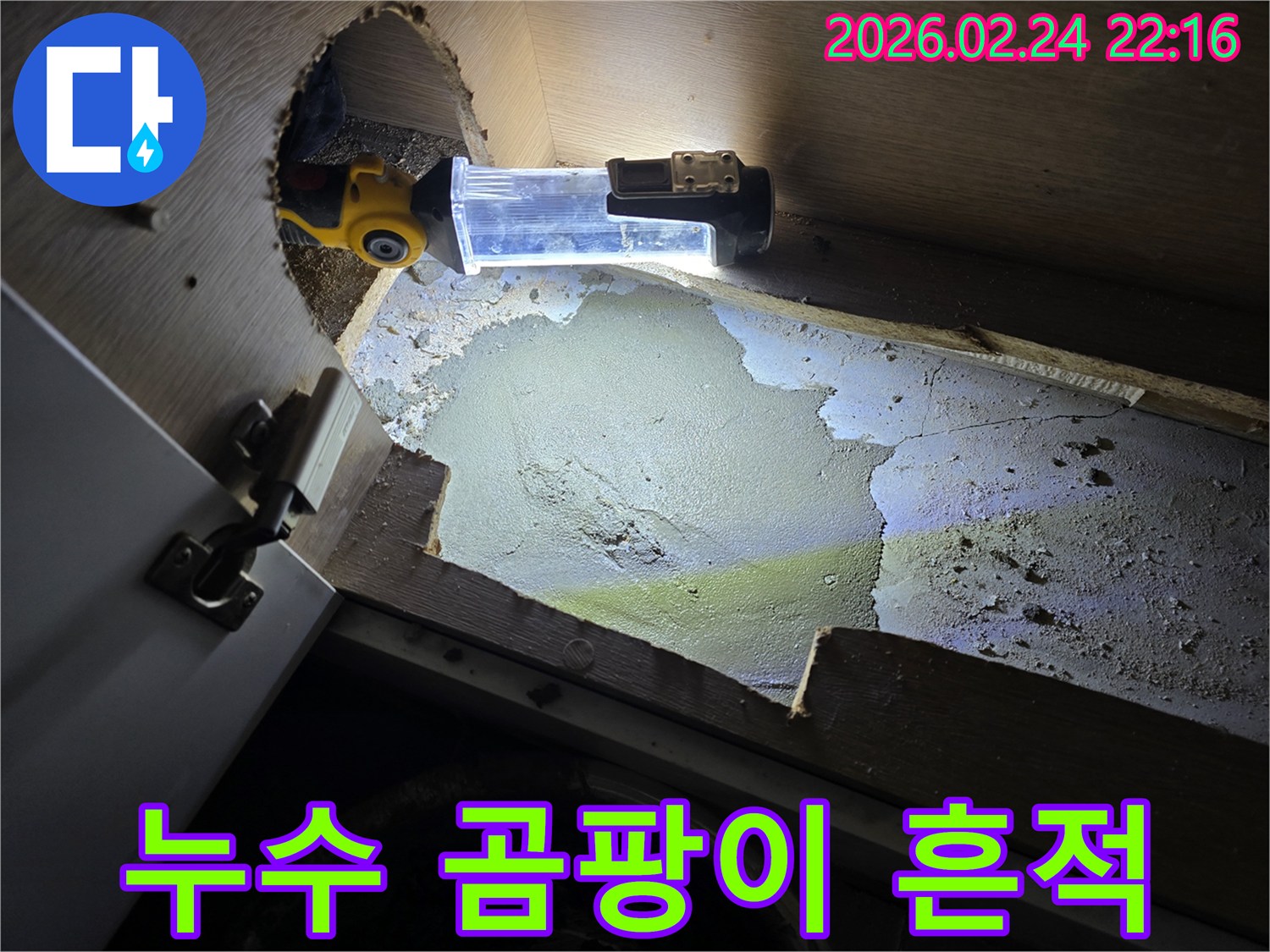 누수로-인해-싱크대-하부에-발생한-습기와-곰팡이-흔적을-조명으로-밝혀-확인하는-누수-전문가