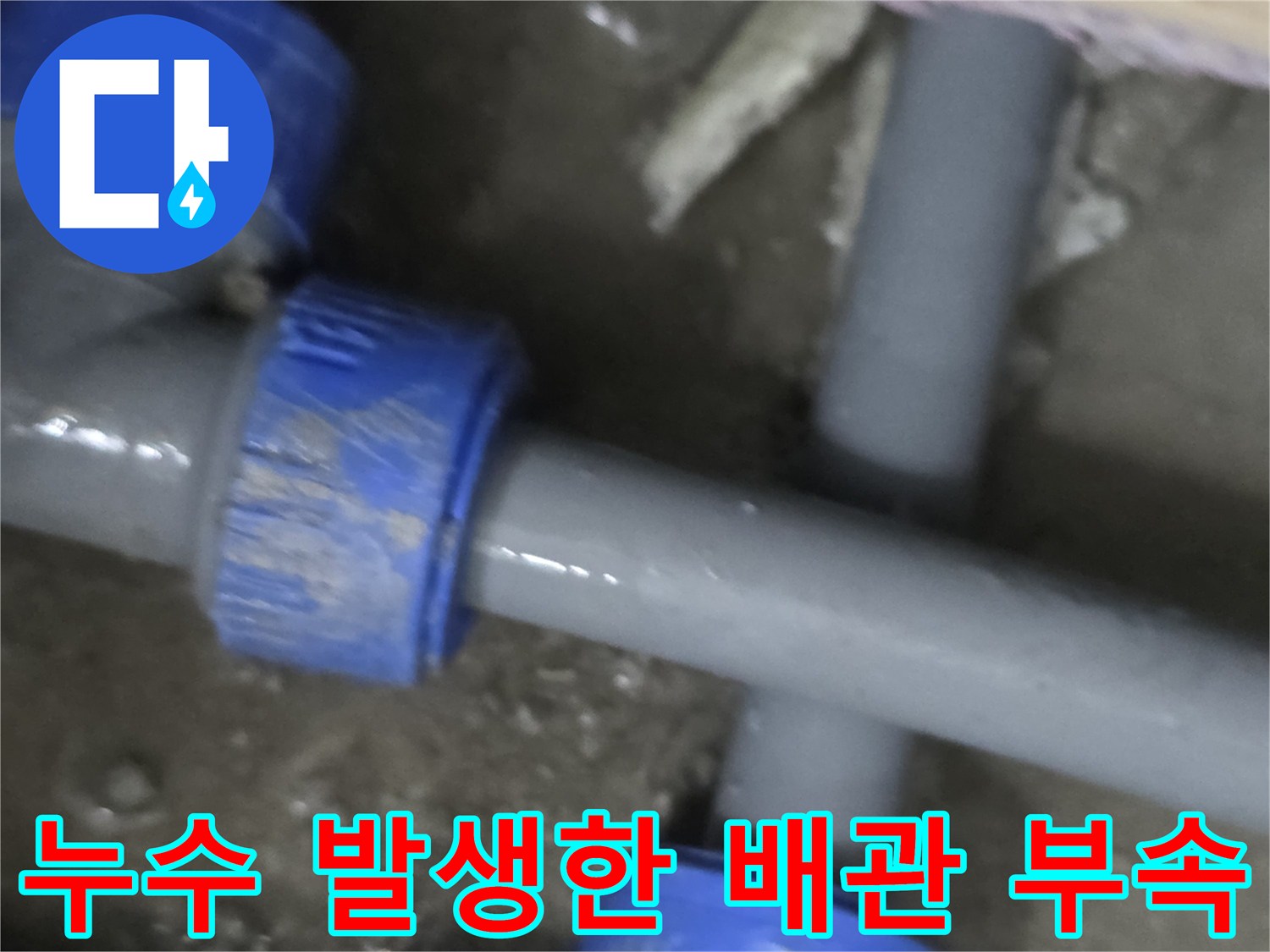 T자형으로 분기된 회색 배관의 연결 부위에서 물이 새는 모습