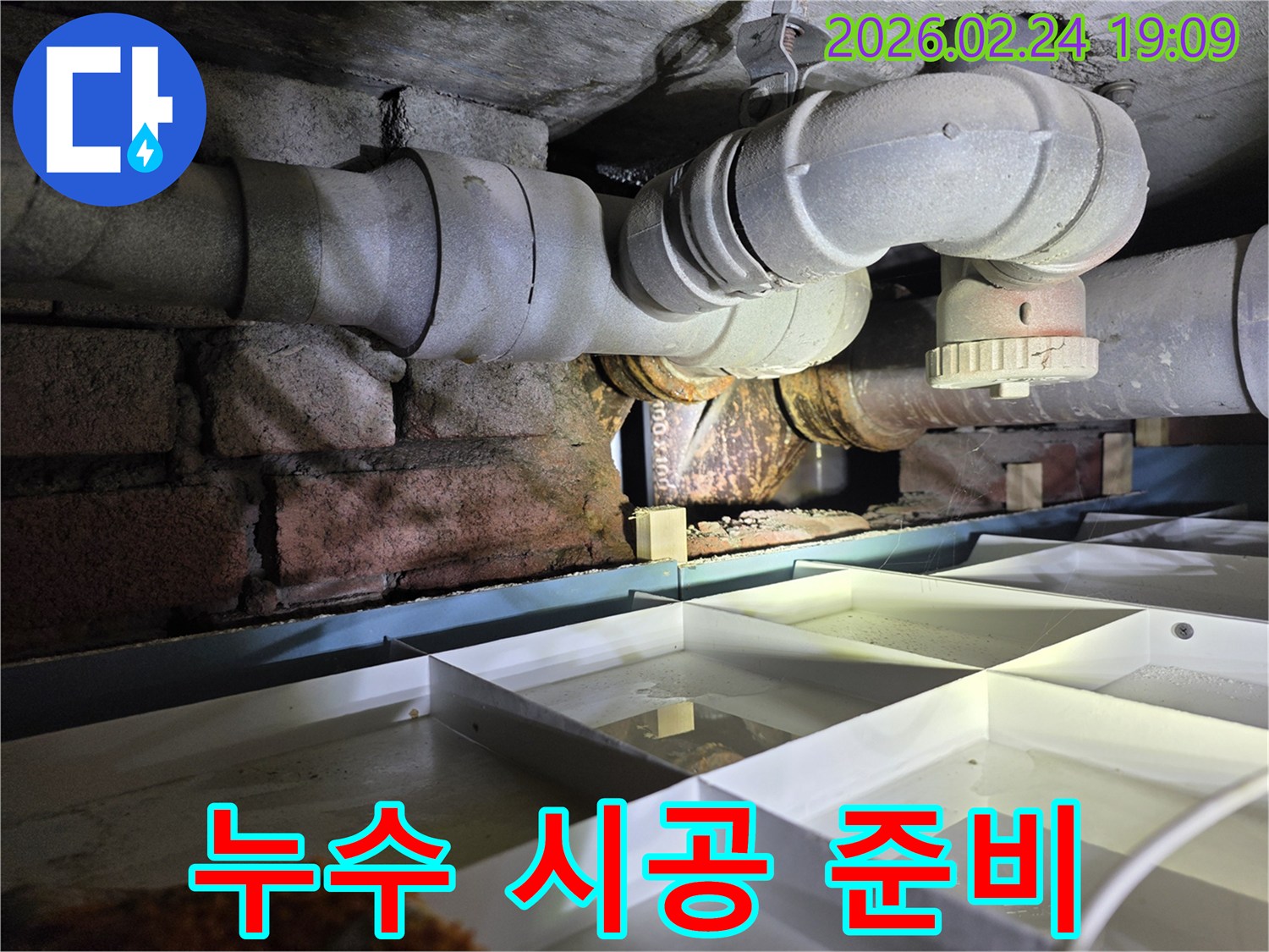 건물-하부의-배관에서-발생한-누수-지점을-확인하고-보수-시공을-준비하는-현장-사진