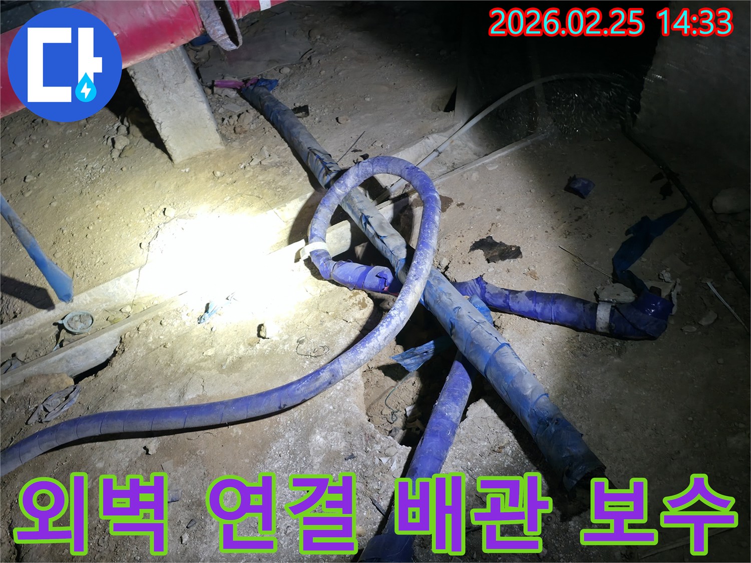 건물 외벽과 연결된-지하 배관에서 발생한 누수를-정밀하게 보수하는-전문가의 작업 현장입니다