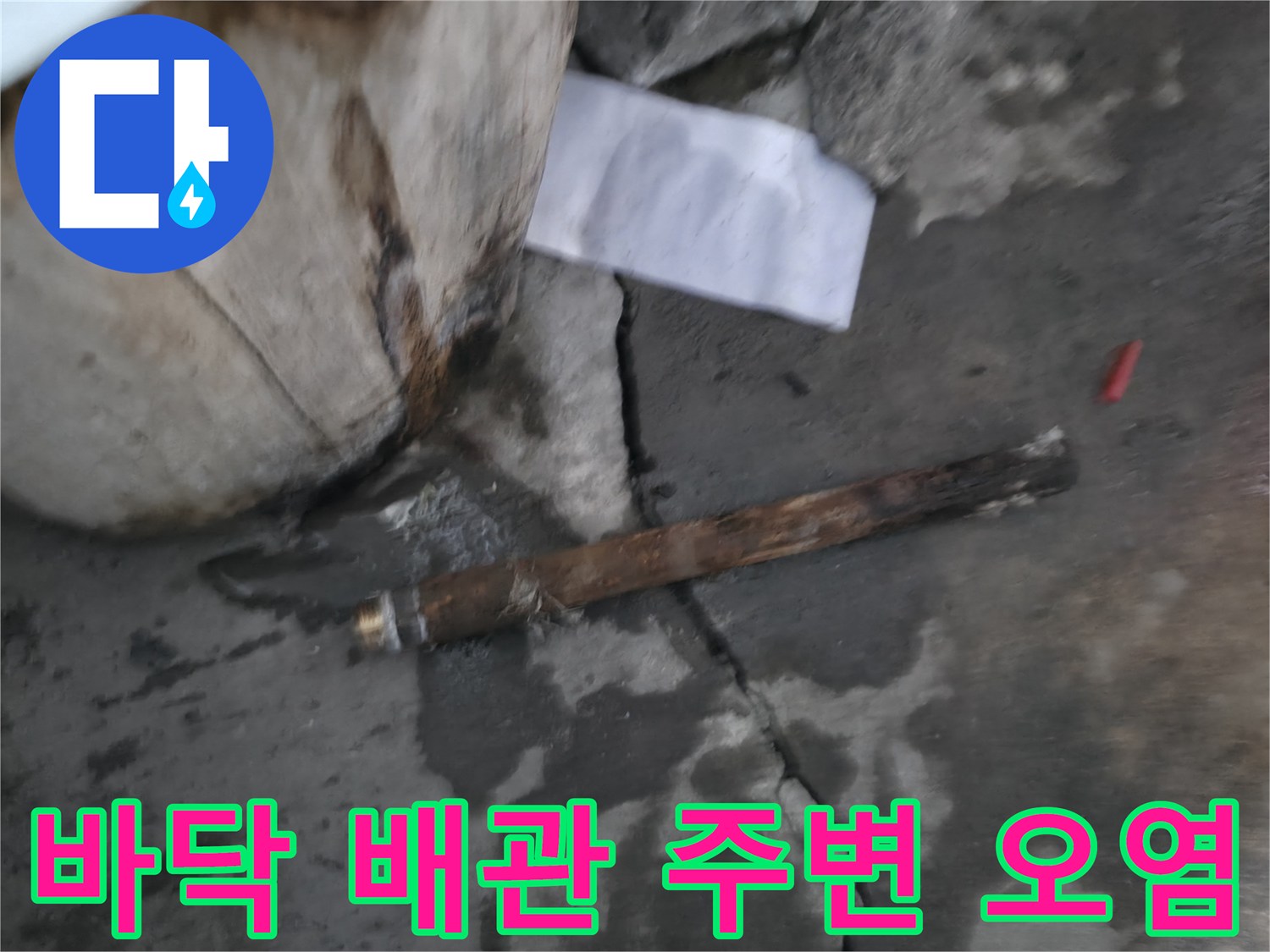배관 근처 콘크리트 바닥에 발생한 누수 얼룩과 젖은 지면