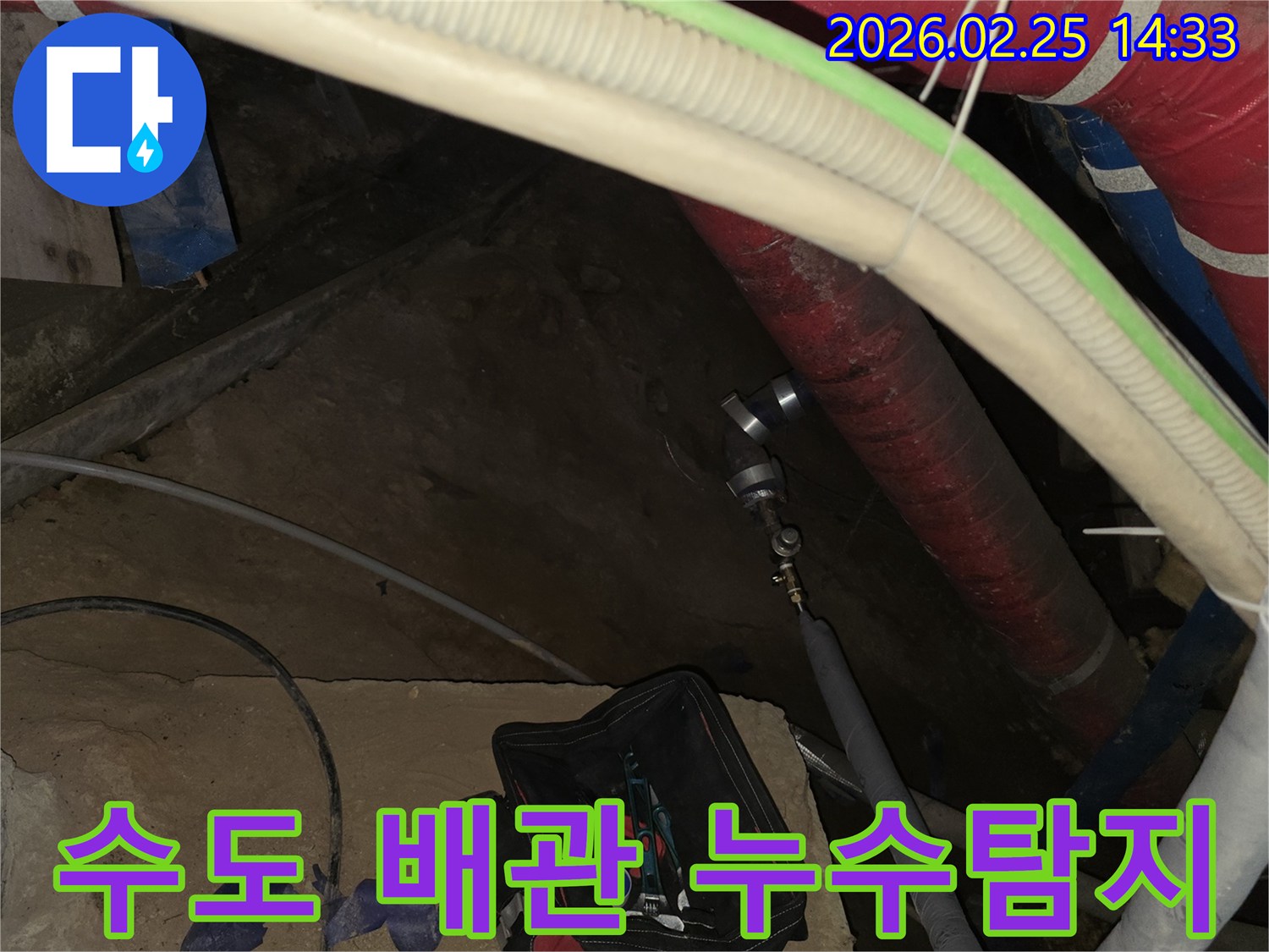 수도 배관에서 발생하는 누수 소리를 멈추기 위해-전문 탐지 장비를 연결하여-정밀 검사를 진행하는 현장입니다.