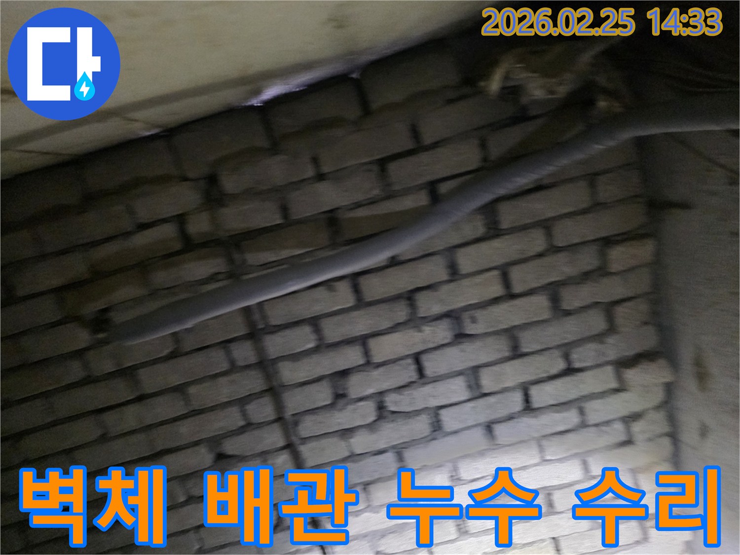 어두운 벽돌 벽면을 배경으로-단열된 배관과 함께-누수 지점을 탐지하고-수리하기 위해 검사되는 현장 모습입니다.