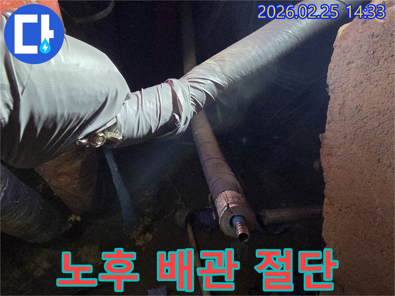 어두운 작업 공간에서-장갑을 낀 손이-노후된 배관을-정확하게 절단하여-새로운 배관으로-교체할 준비를 하는-모습입니다