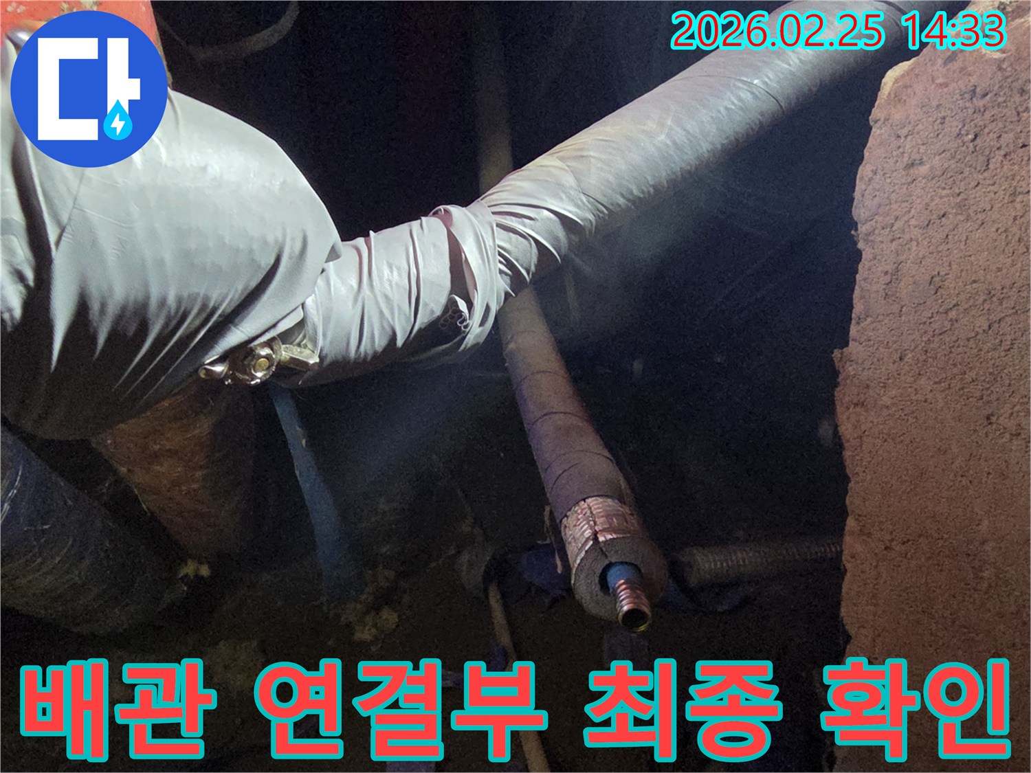 어두운 작업 공간에서-장갑을 낀 손이-누수 공사 완료 후-배관의 모든 연결 부위를-세심하게 최종 점검하는-모습입니다