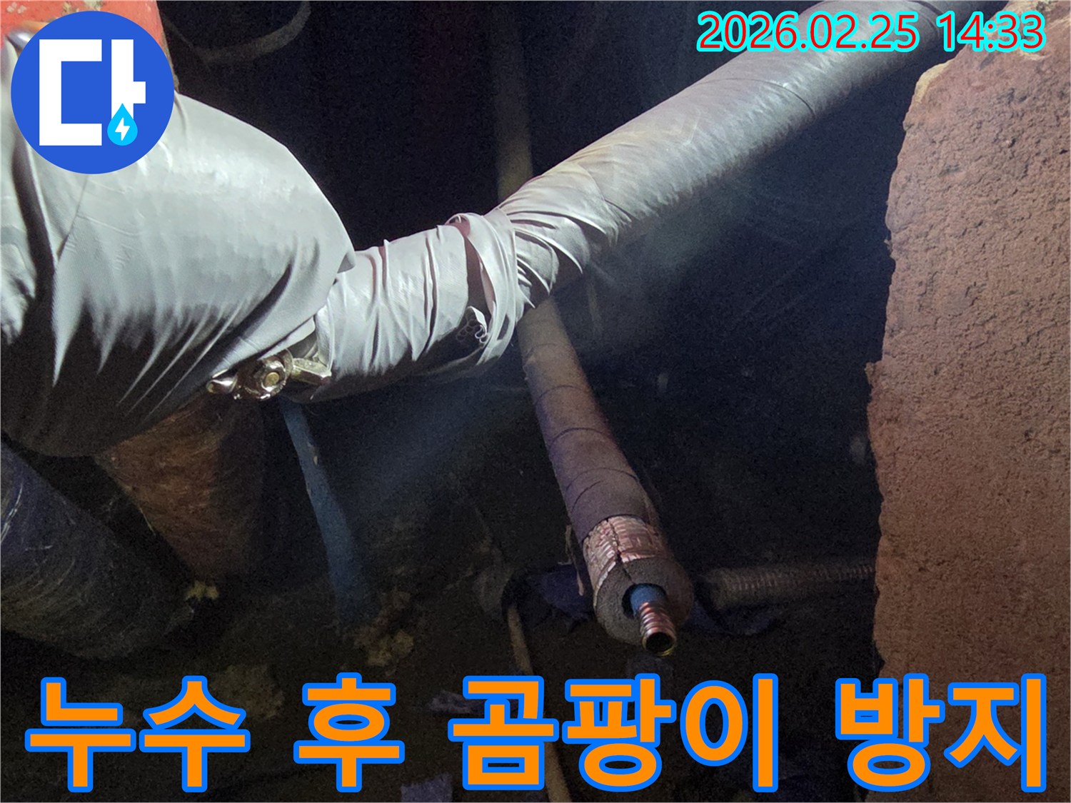 어두운 작업 공간에서-장갑을 낀 손이-누수로 인해-손상된 배관을-수리하며-곰팡이 발생을-방지하기 위한-조치를 취하는 모습입니다