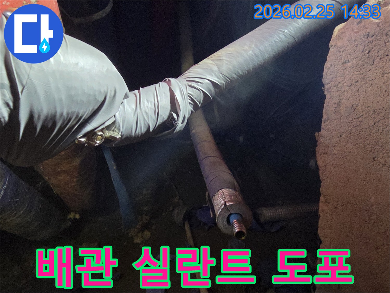 어두운 작업 공간에서-장갑을 낀 손이-배관의 연결 부위에-누수 방지용-특수 실란트를-꼼꼼하게 도포하는-모습입니다