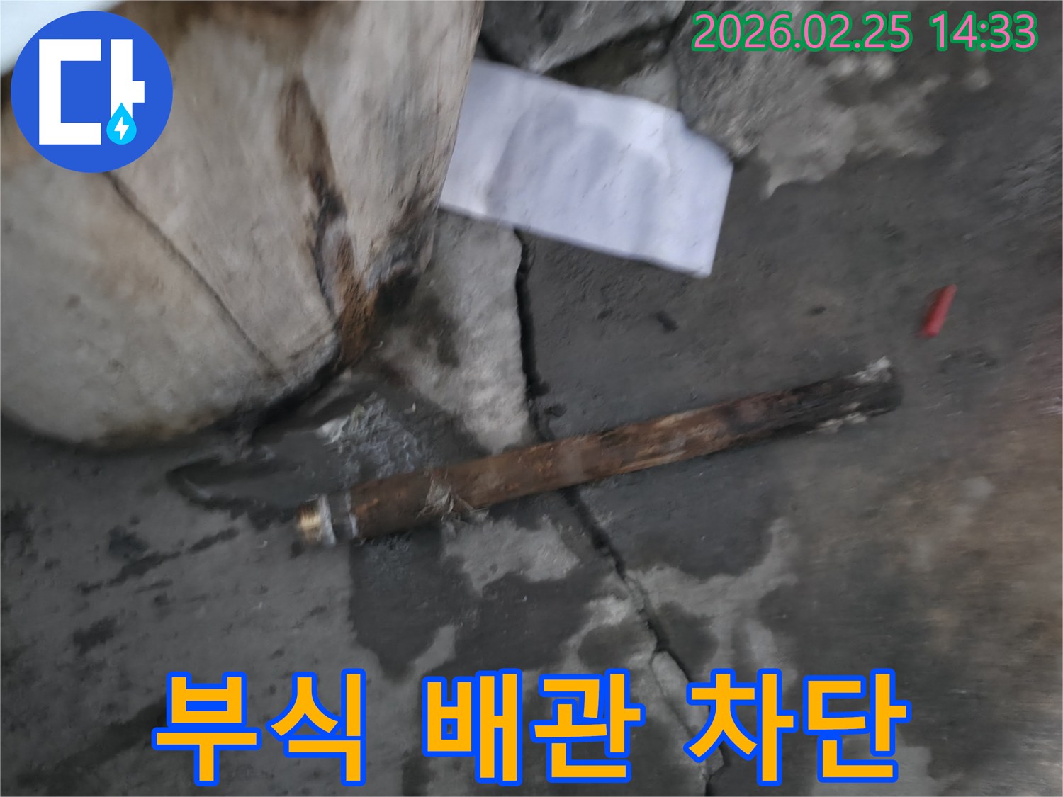 오랜 사용으로 부식되어-파열된 배관이-젖은 바닥에 놓여있는-누수 현장 사진입니다.
