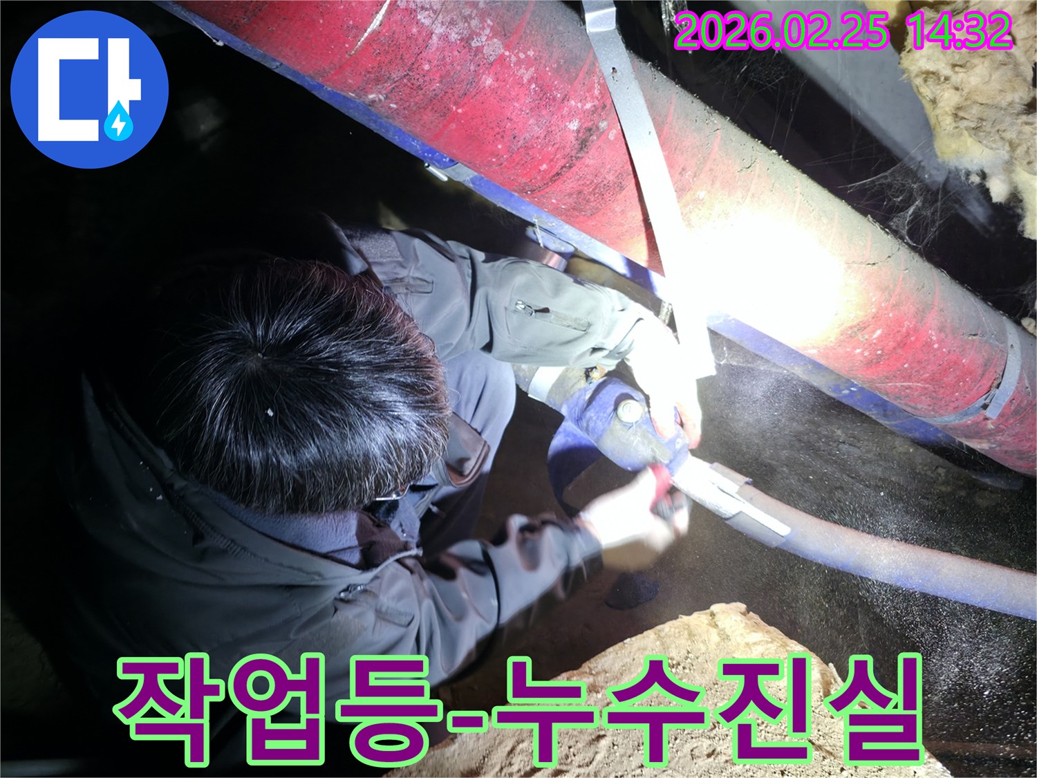 전문 엔지니어가-강력한 작업등을 사용하여-어둡고 좁은 공간에서-숨겨진 누수의 진실을-밝혀내고 있습니다