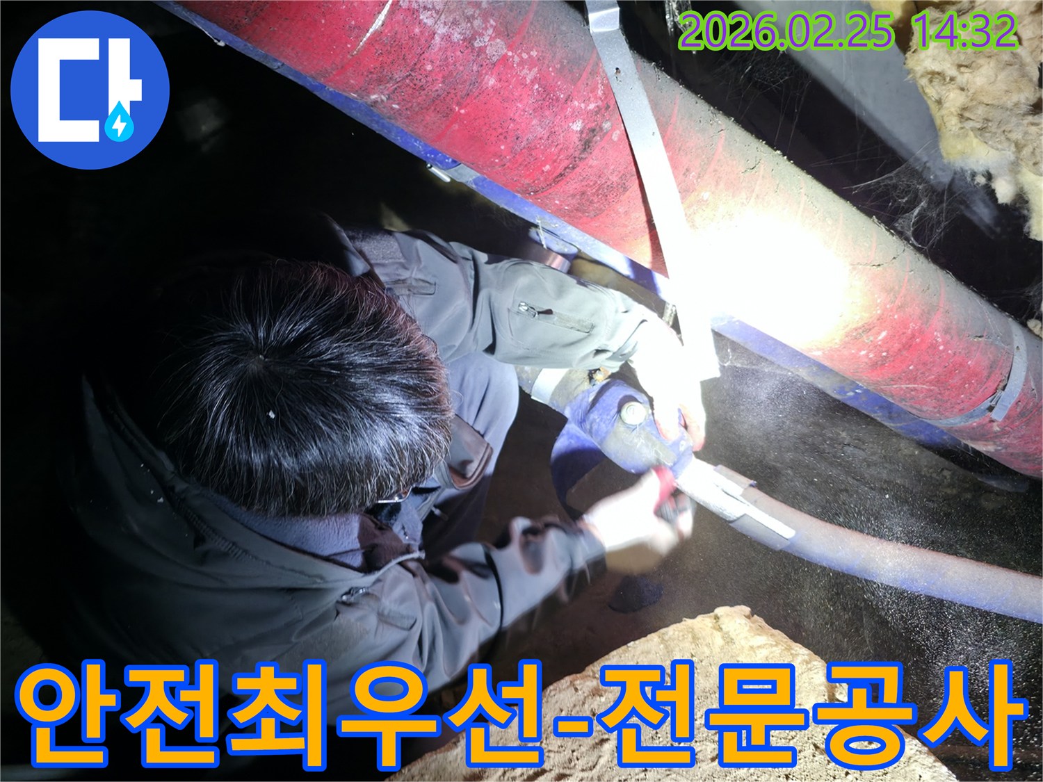 전문 엔지니어가-어둡고 좁은 공간에서-안전 장비를 착용하고-작업등을 비추며-안전을 최우선으로-누수 공사를 진행하고 있습니다
