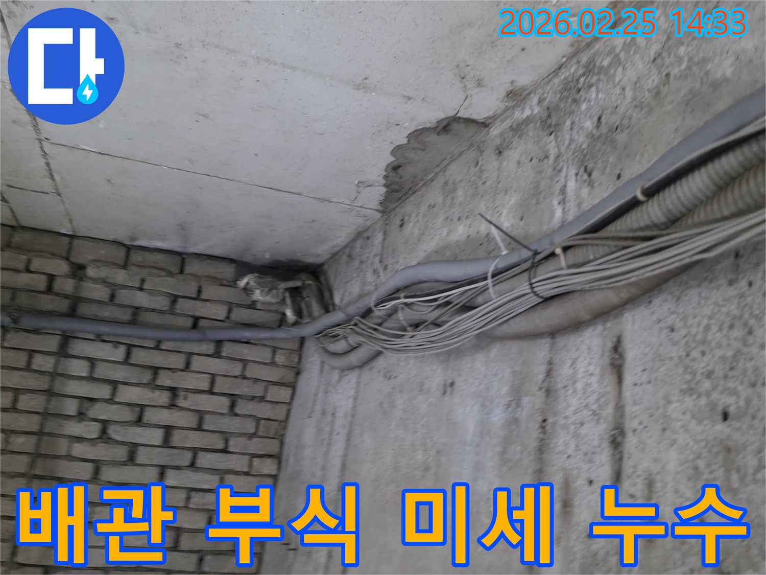 지하 벽면의-콘크리트와-벽돌 벽이 만나는-지점에서-발견된-오랜 누수로 인한-물자국과-주변의 복잡한 배관