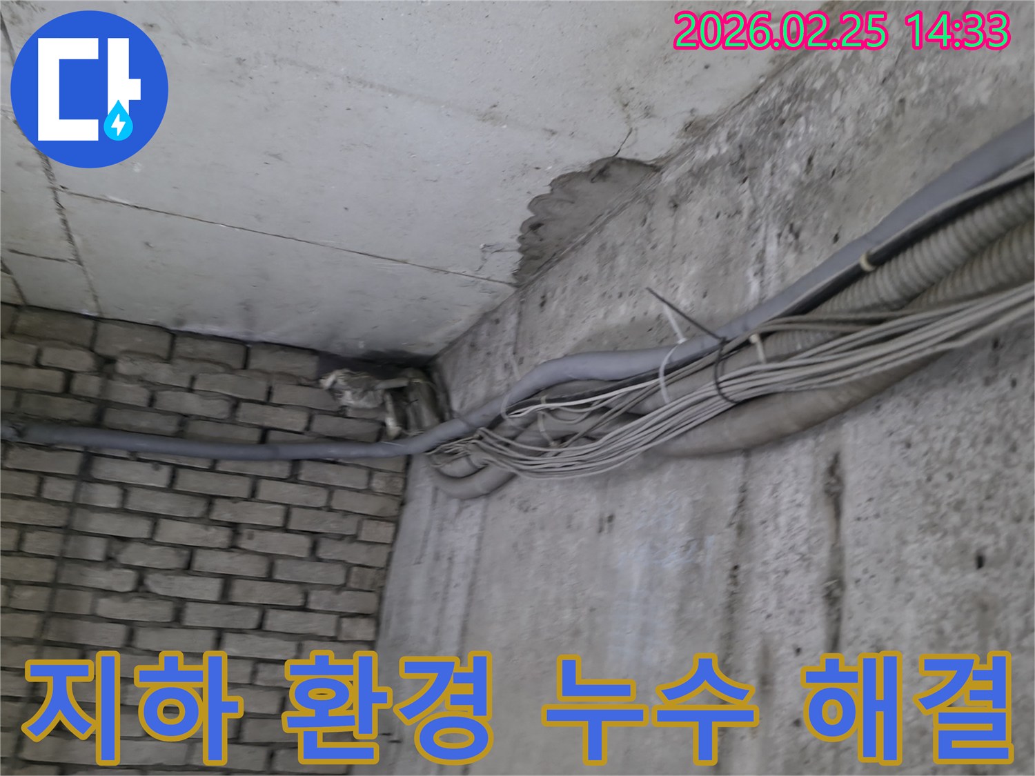 지하 벽면의-콘크리트와-벽돌 벽이 만나는-지점에서-발견된-오랜 누수로 인한-물자국과-주변의 복잡한 배관