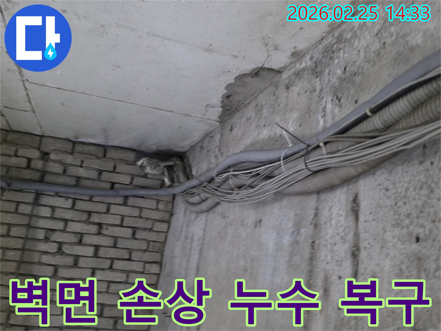 지하 벽면의-콘크리트와-벽돌 벽이 만나는-지점에서-발견된-오랜 누수로 인한-물자국과-주변의 복잡한 배관